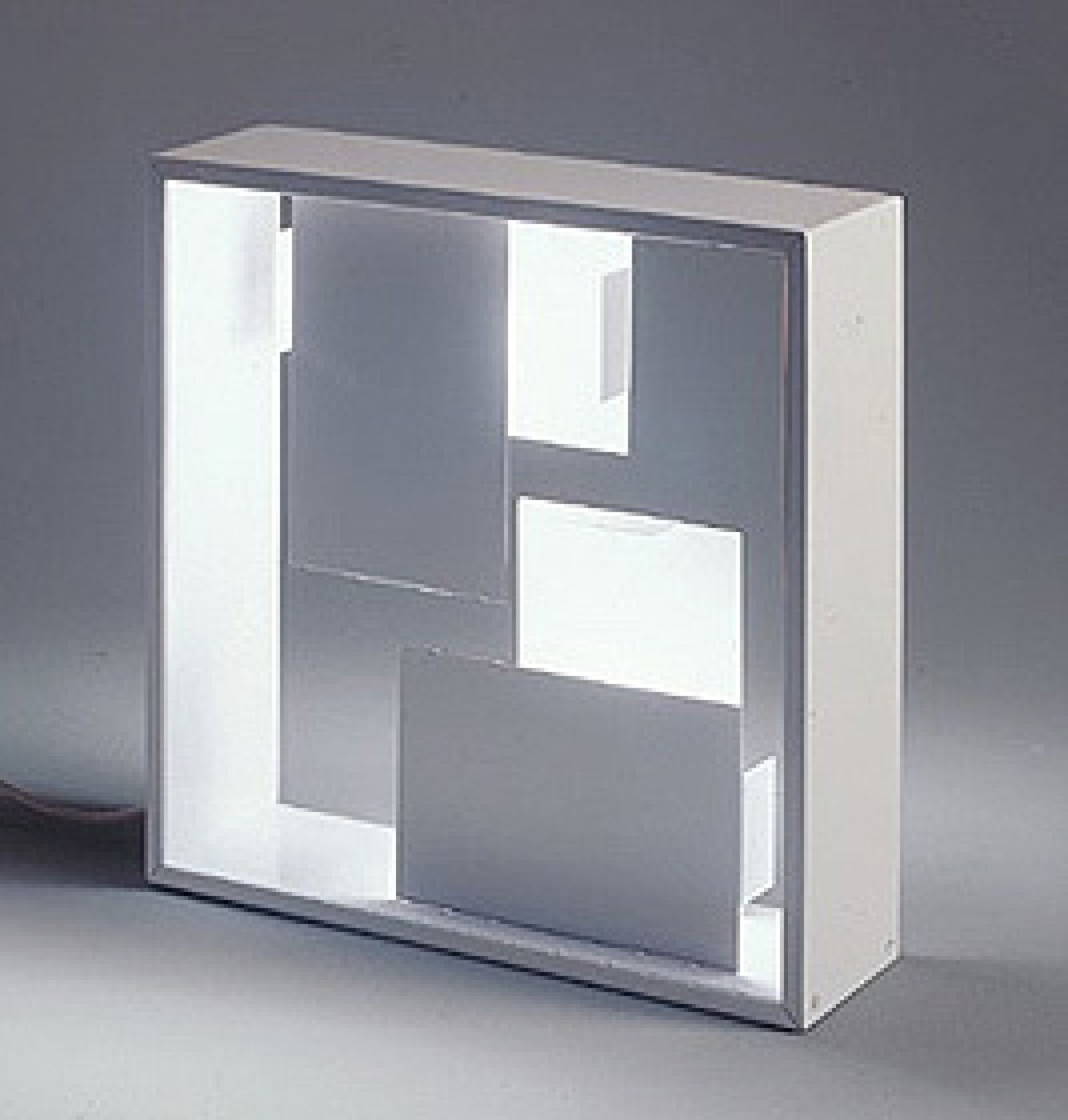 Weiße Fato Tischleuchte von Artemide mit geometrischen Formen und hellem Lichtschein. Design Lampe.