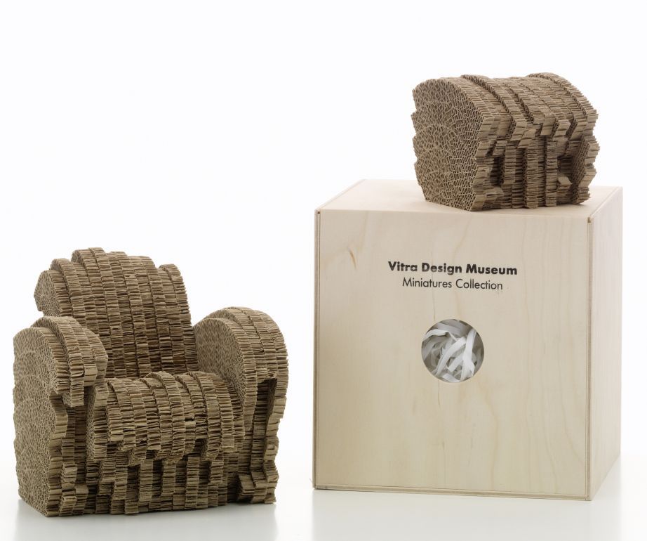Miniatur Sessel "Little Beaver" von Vitra aus Pappe, neben Holzkiste der Miniaturen Kollektion.