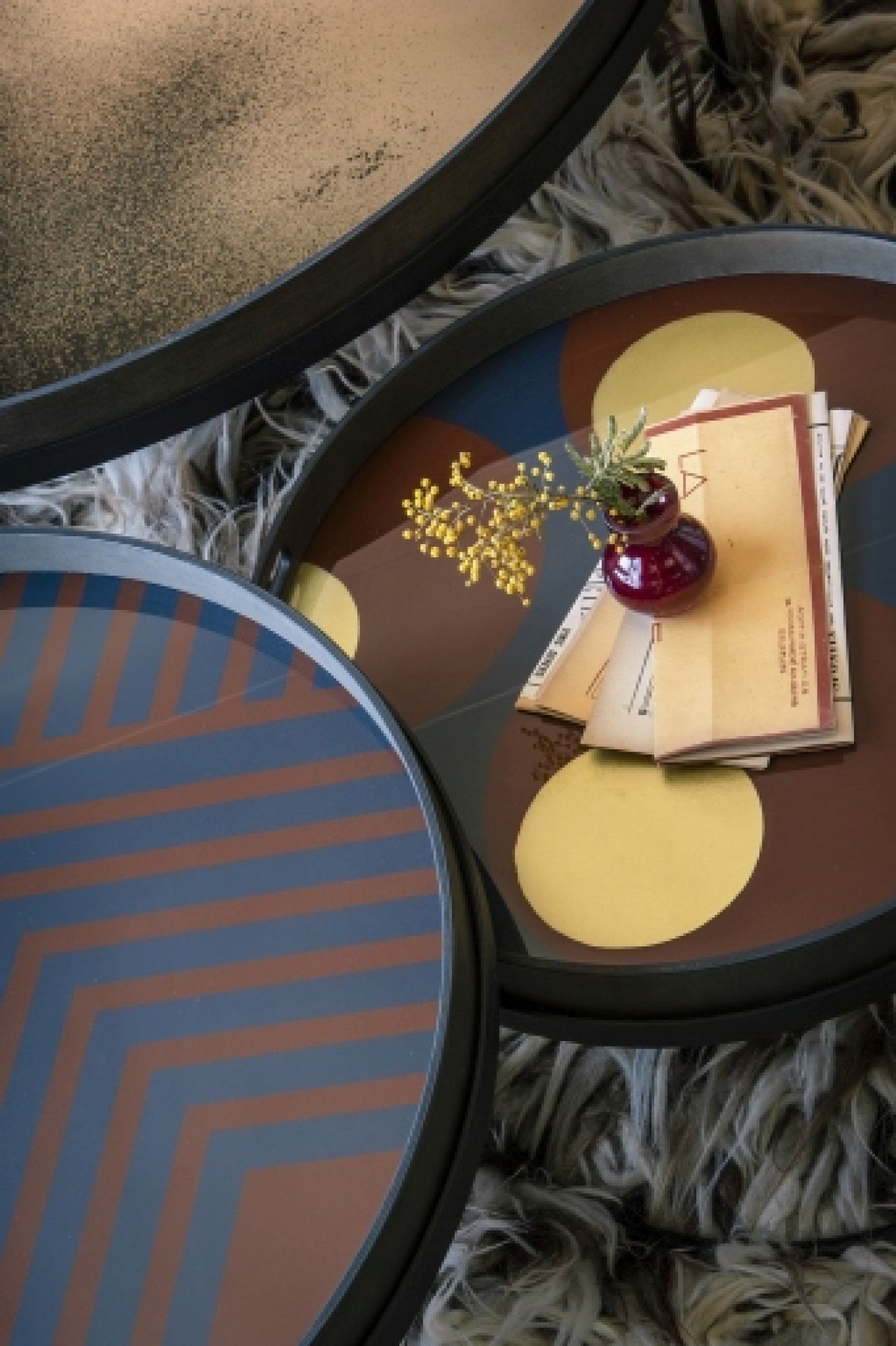 Detailaufnahme von drei runden Ethnicraft Wandspiegeln mit Mustern und Dekoration auf einem Teppich.