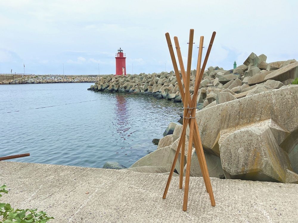 Mary Garderobenständer aus Eiche von Keilbach Designprodukte mit fünf Stäben vor Küstenkulisse. Moderner Garderobenständer für Flur und Diele.