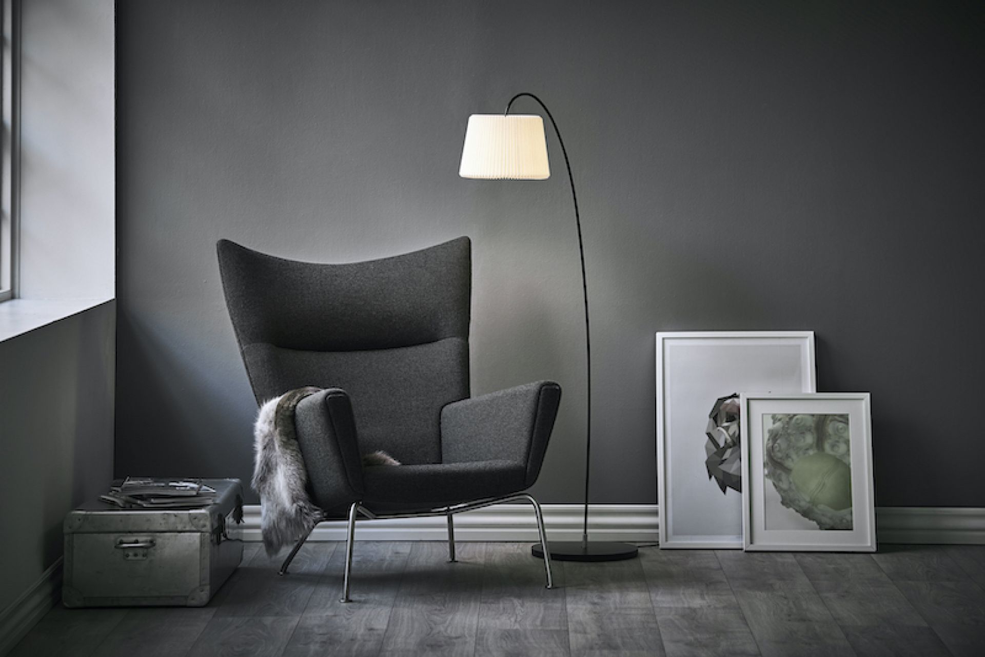 Snowdrop Stehleuchte von Le Klint neben Sessel und Bildern im Wohnzimmer.