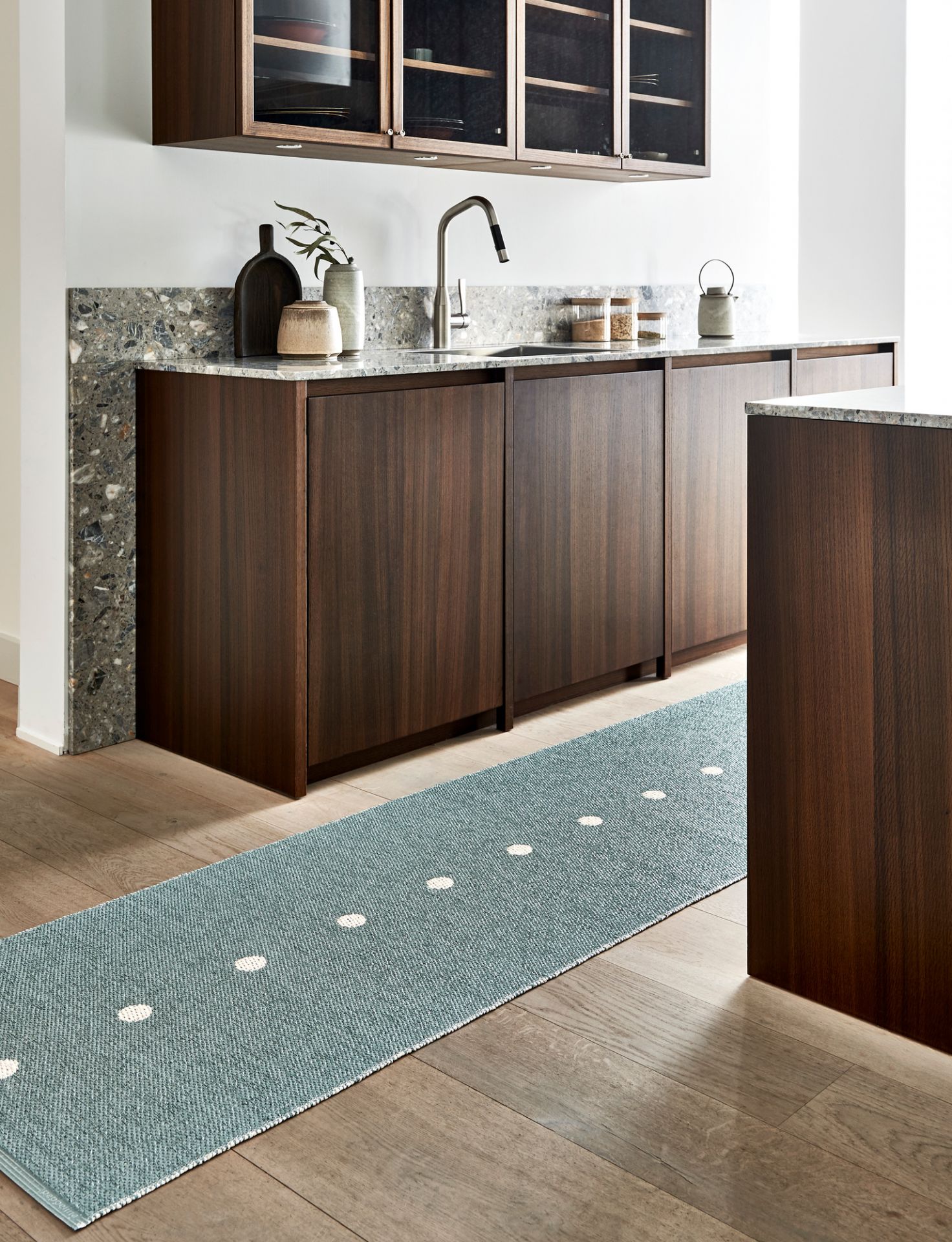 Blauer Pappelina Kunststoffteppich "Peg" (70x280 cm) mit weißen Punkten in moderner Küche auf Holzboden.