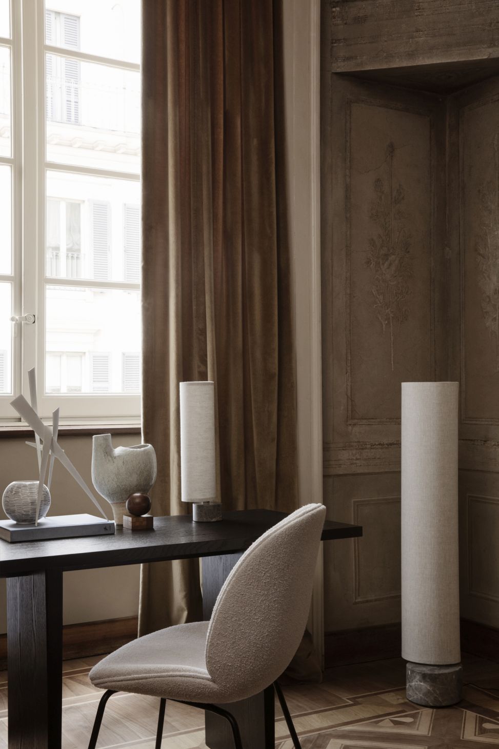 Nahaufnahme des Gubi Private Desk Schreibtischs mit Stuhl und Deko in einem eleganten Arbeitszimmer.