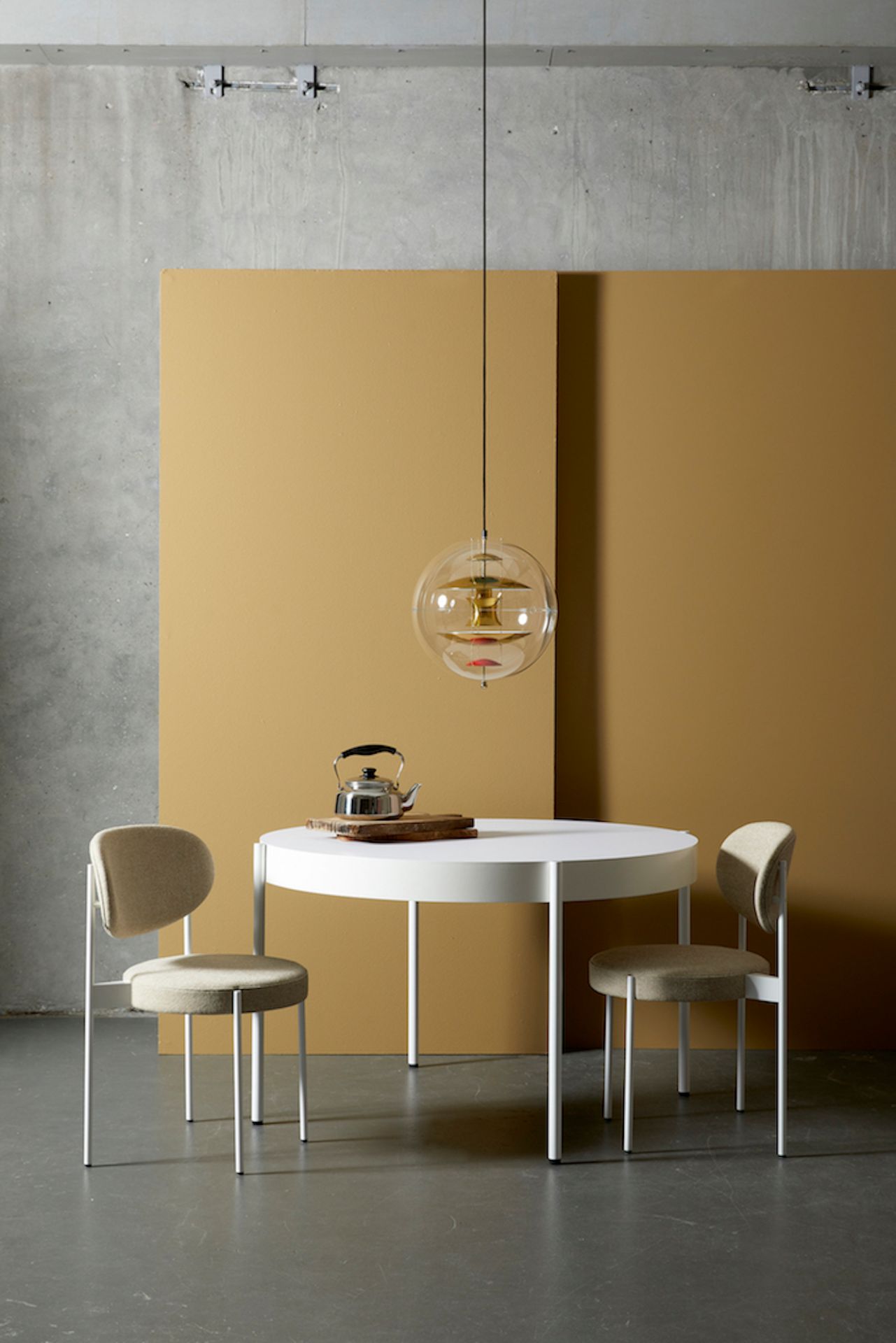 VP Globe Pendelleuchte von Verpan über Esstisch mit Teekessel und zwei Stühlen.