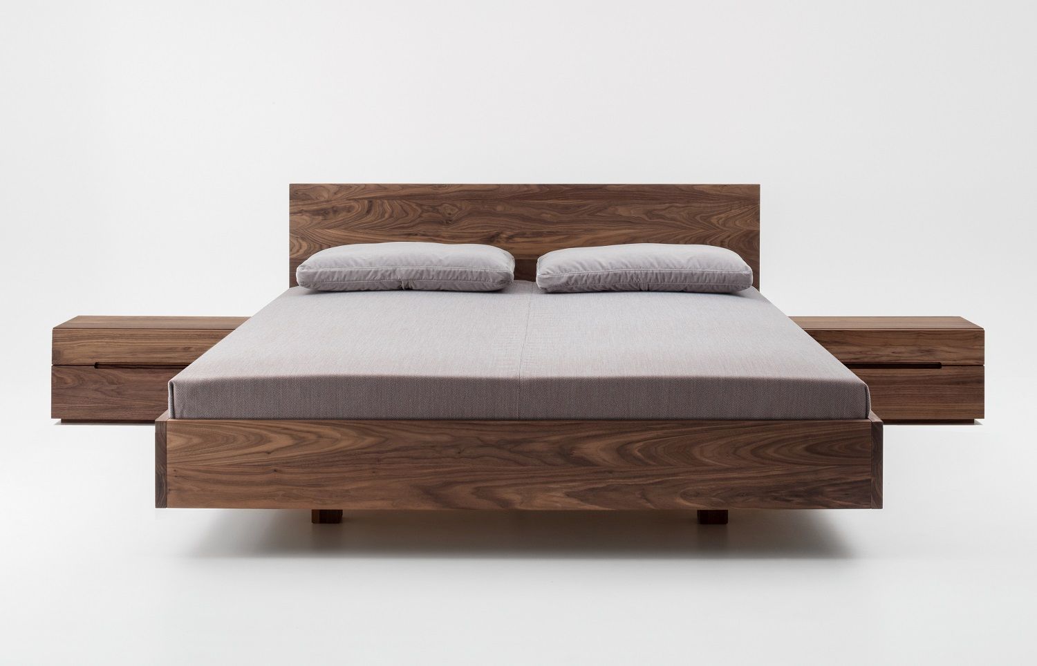 Nightstand 64 Nachttisch aus Holz neben einem passenden Bett mit Nachttischen.