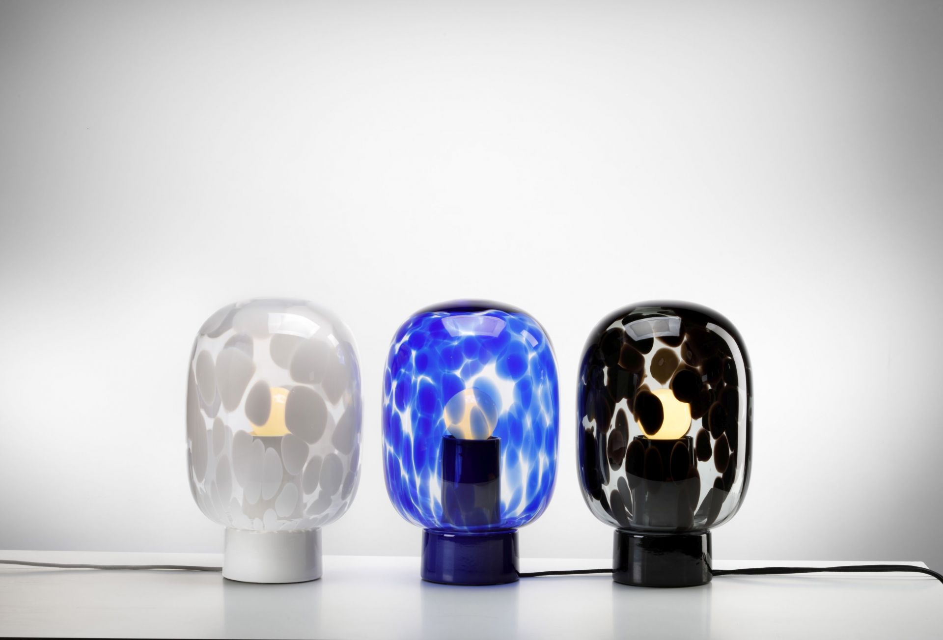 Flakes Tischleuchte Favius, rauchgrau und schwarz. Moderne Lampe mit gepunktetem Glasdesign.