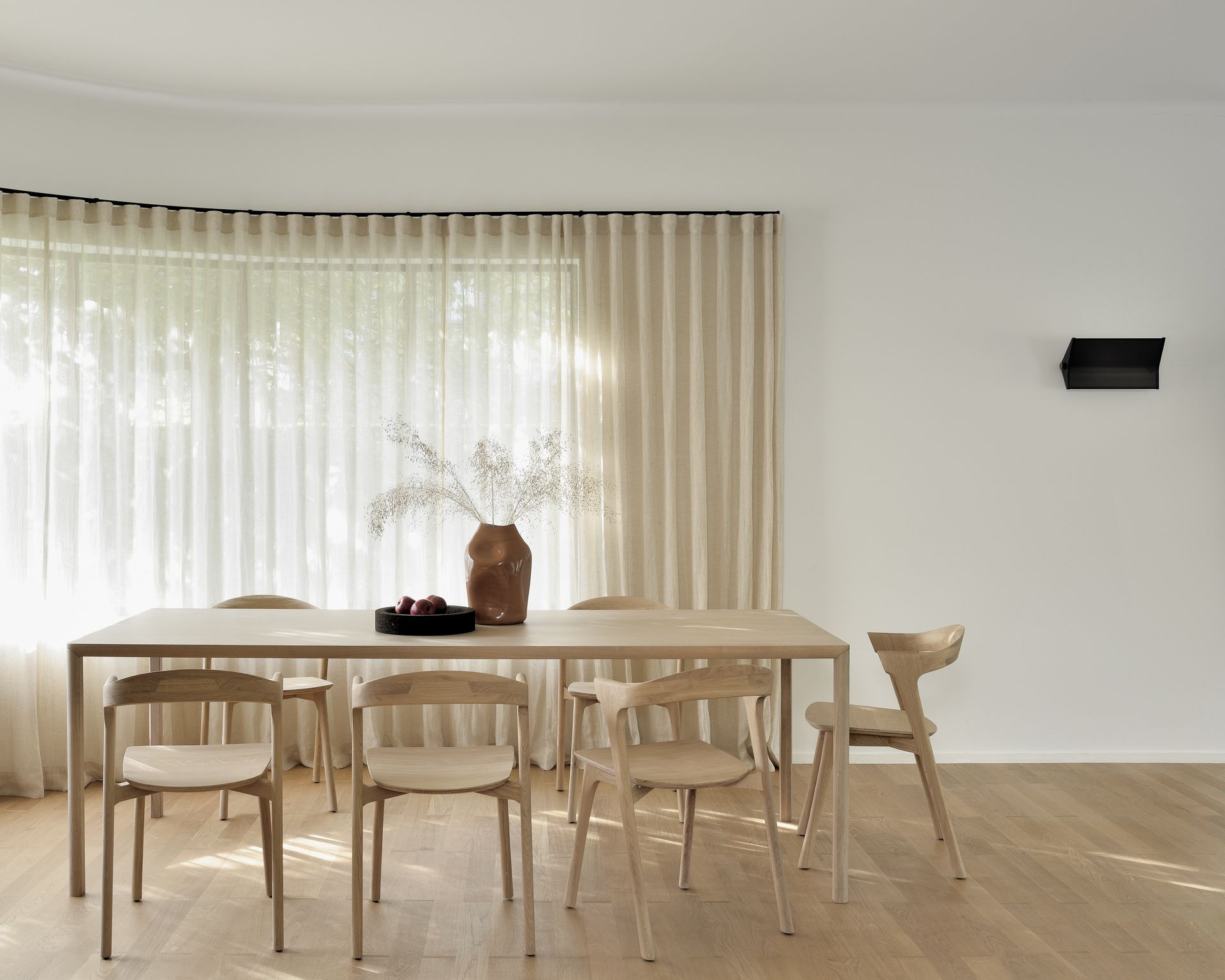 Ethnicraft Air Tisch aus Eiche, rechteckig, mit Stühlen in einem hellen Esszimmer.