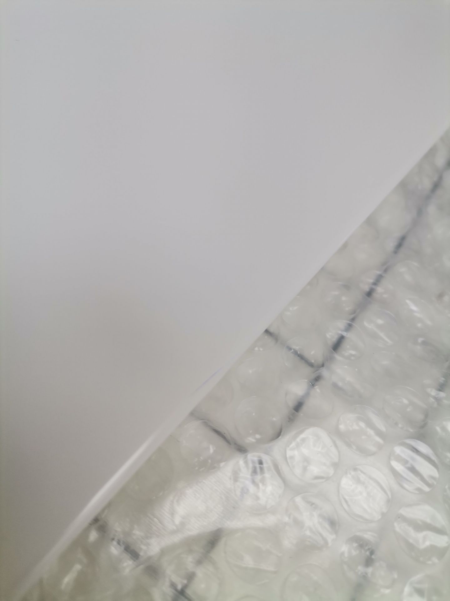 Nahaufnahme von USM Haller Ersatzteilen (Mängelexemplar) verpackt in Luftpolsterfolie, bereit für den Versand.