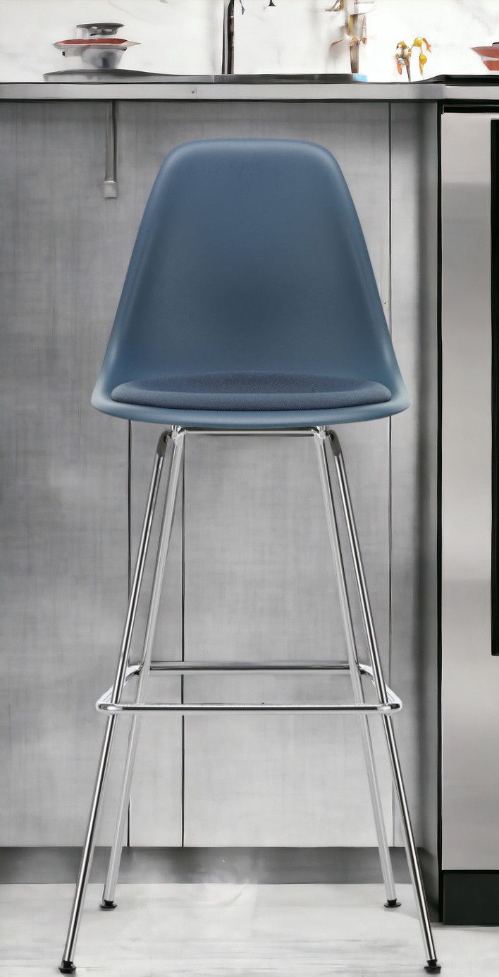 Blauer Eames Plastic Bar Stool Barhocker von Vitra mit Sitzpolster und Chromgestell.