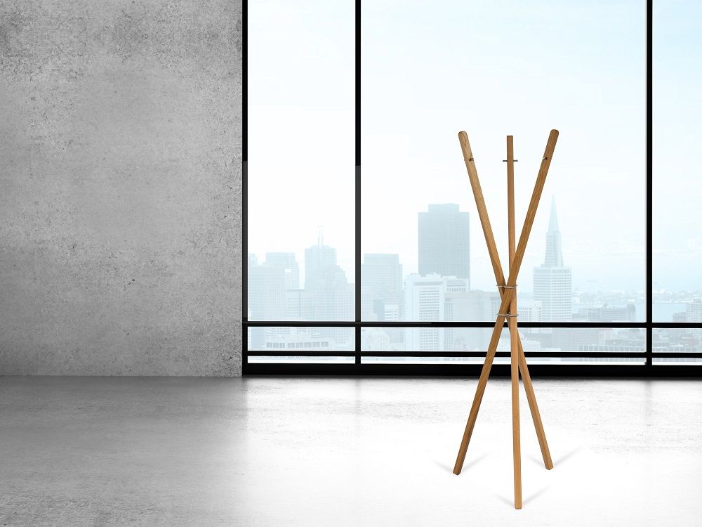 Mia Garderobenständer mit drei Holzstäben von Keilbach Designprodukte vor einem Fenster mit Stadtblick.