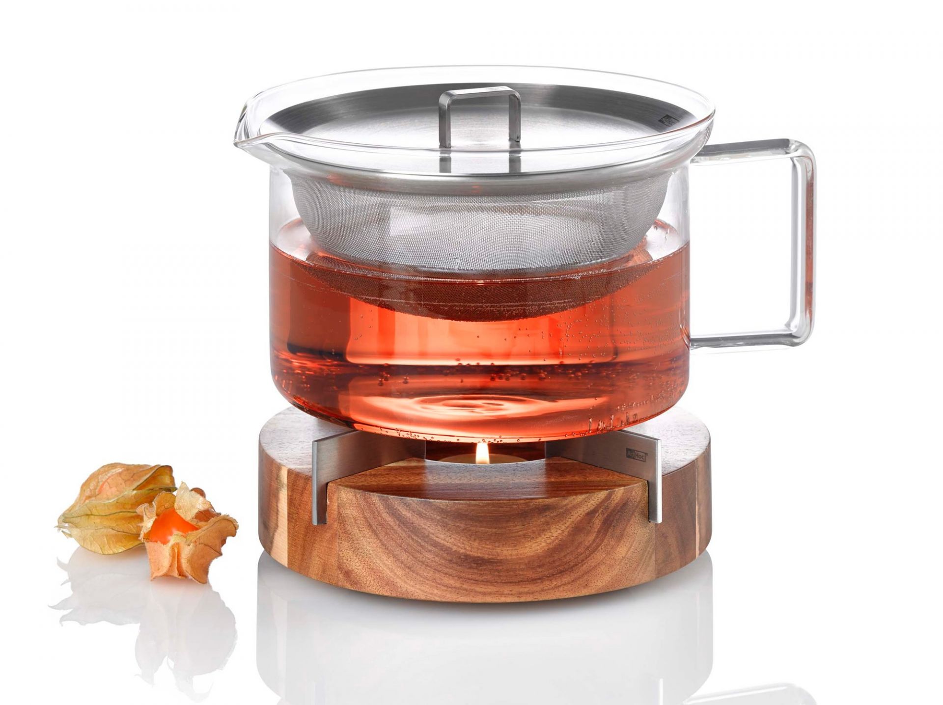 AdHoc Stövchen: Teekanne aus Glas mit Teesieb auf Holz-Speisenwärmer mit Teelicht.