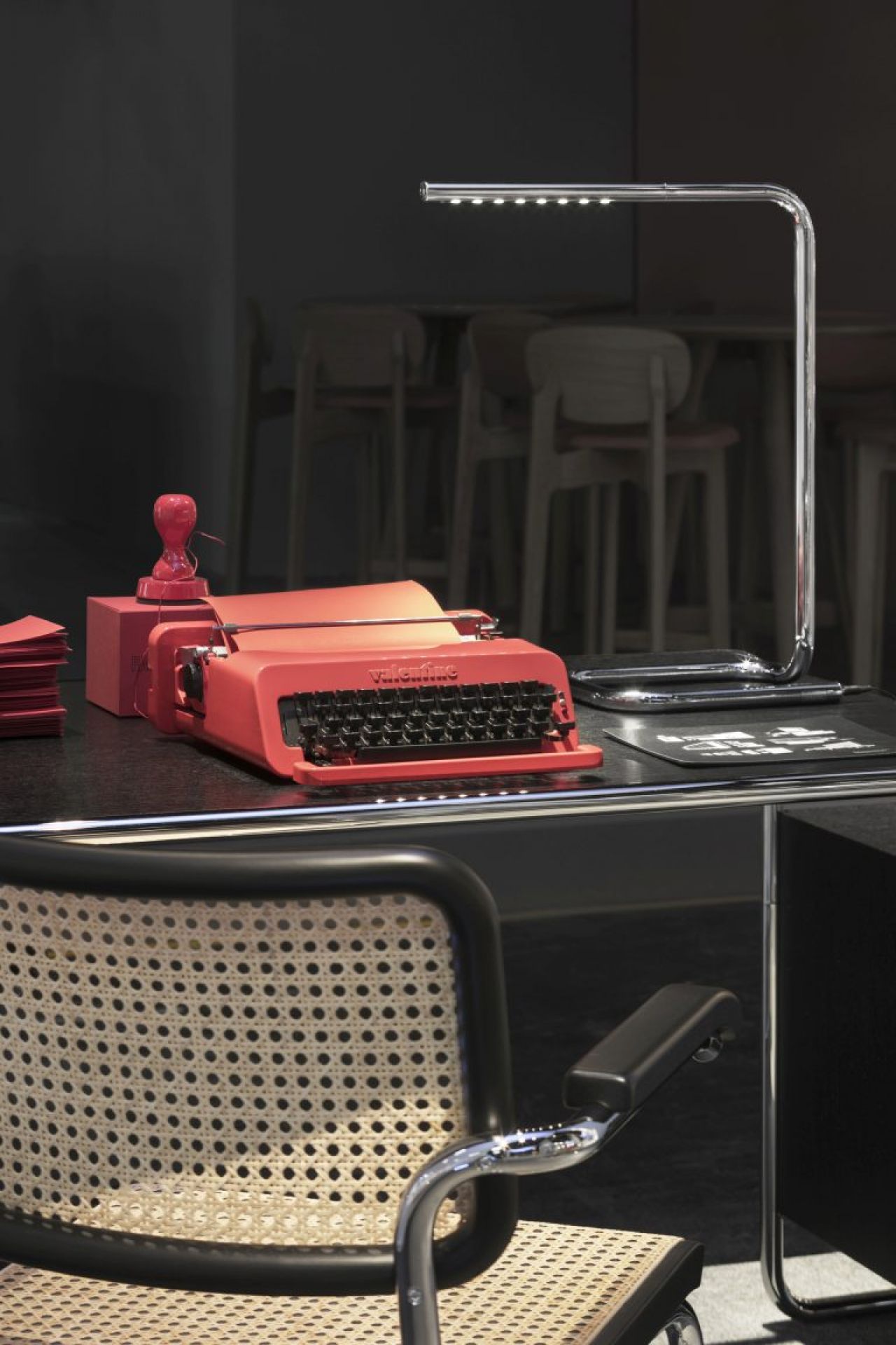 Nahaufnahme der Lum 50 Tischleuchte von Thonet, verchromt, auf einem Schreibtisch mit Schreibmaschine.