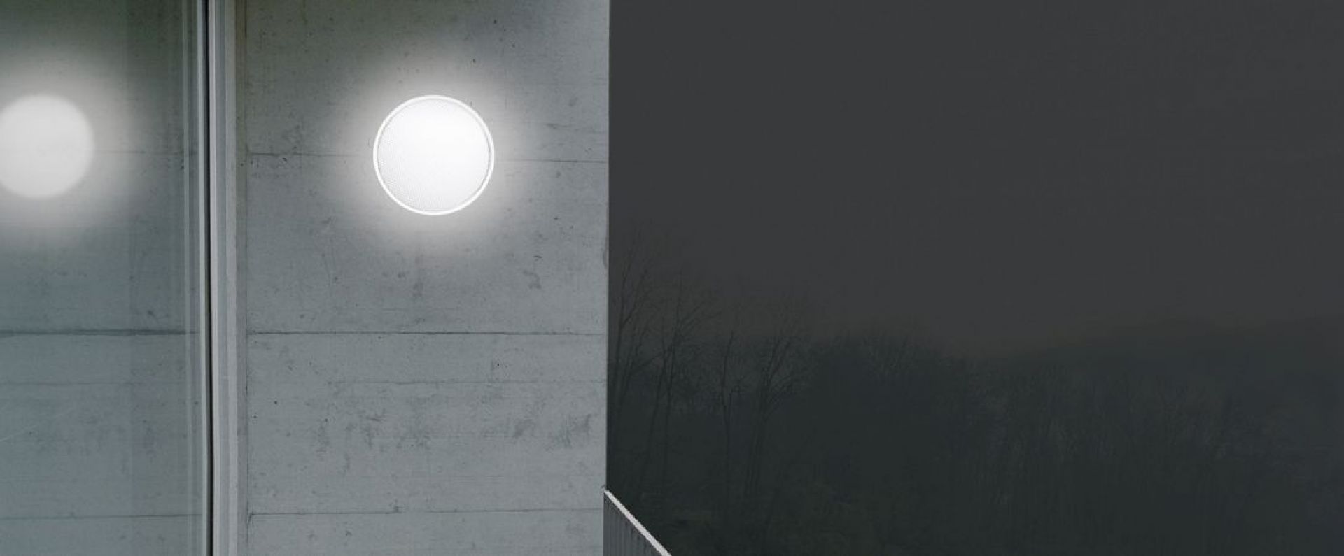 O-lite Wandleuchte: Runde Deckenleuchte mit warmweißem Licht an einer Betonwand. Innenbeleuchtung.