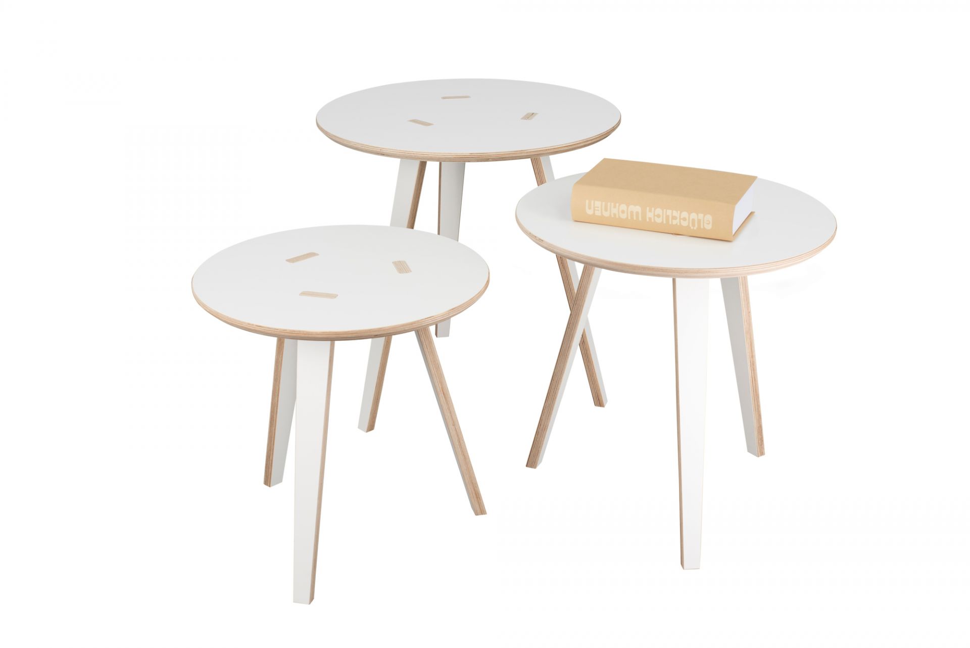 Drei weiße Tojo Tische, runde Beistelltische aus Holz, einer mit Buch, modernes Möbeldesign.