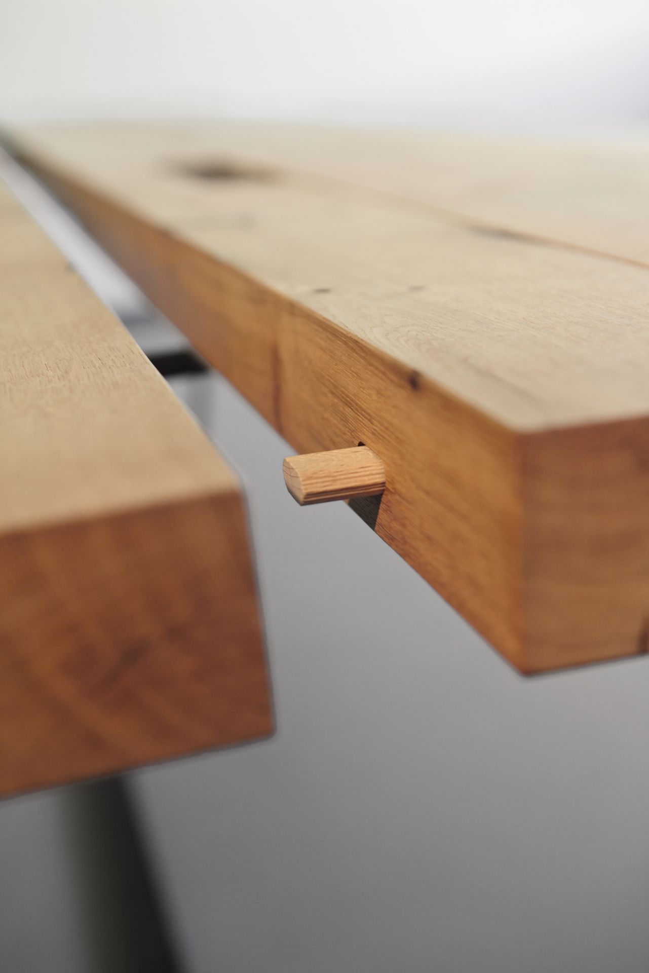 Detailaufnahme des Janua BB 11 Clamp Tisches aus geölter Eiche, Fokus auf die Holzverbindung.