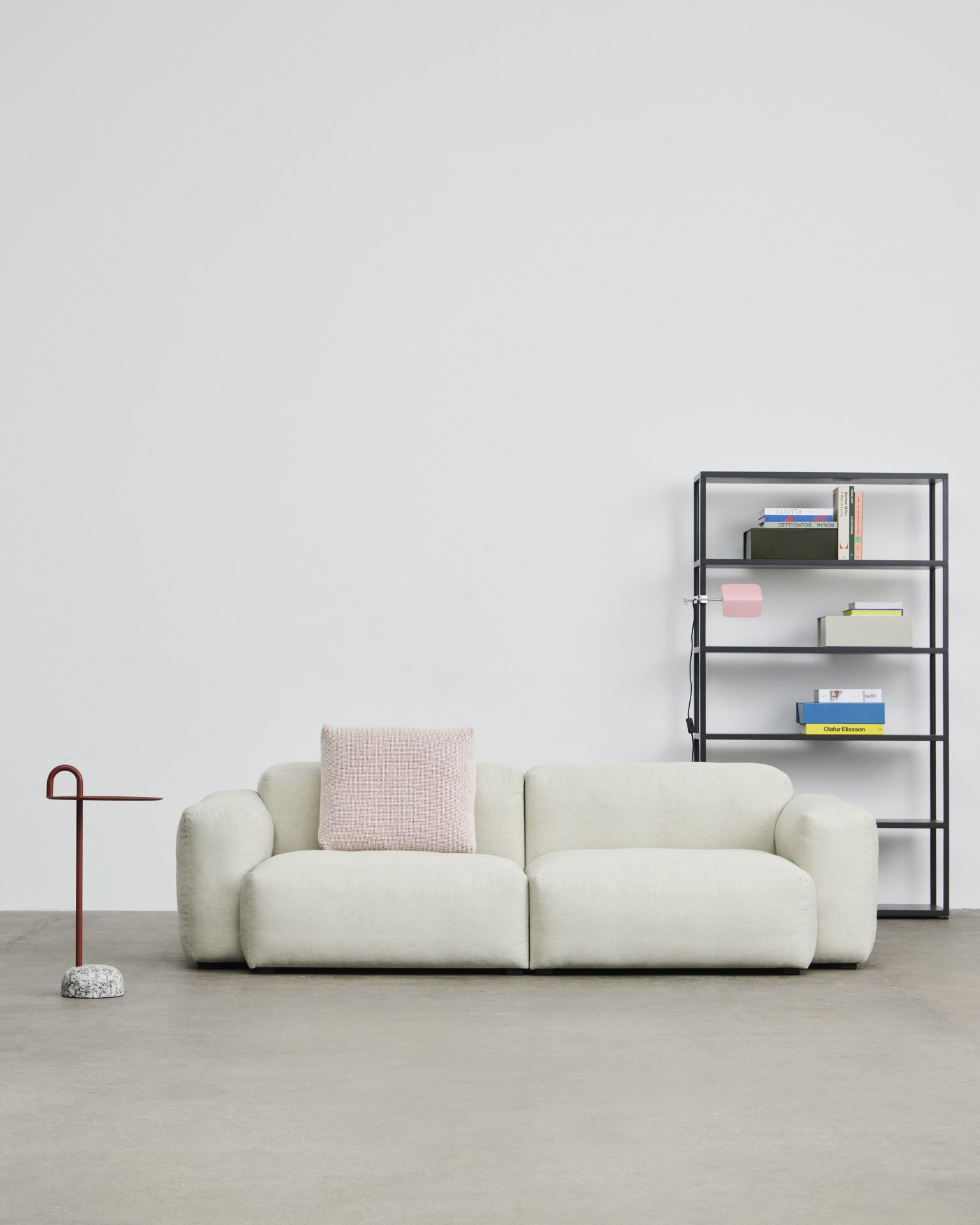 Helles Wohnzimmer mit Hay New Order Regal, Sofa mit Kissen und Beistelltisch.