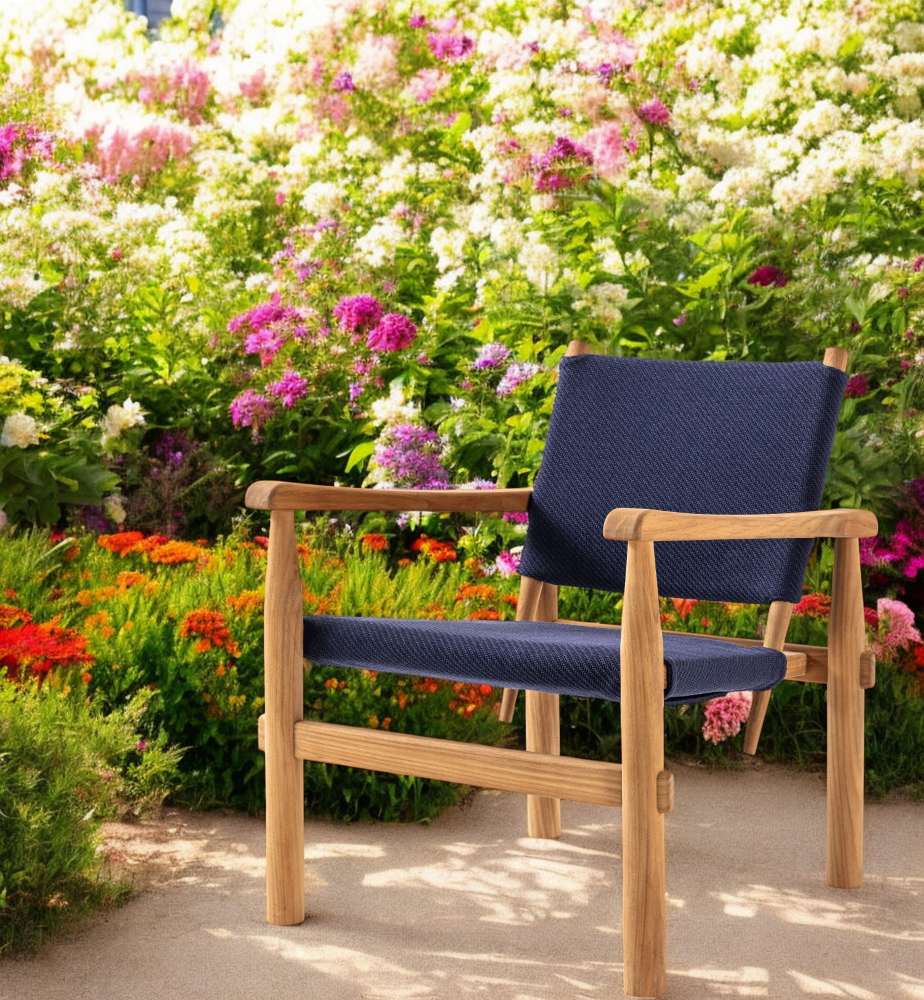 Doron Sessel Outdoor von Cassina: Blauer Gartensessel aus Holz vor blühendem Blumenbeet.