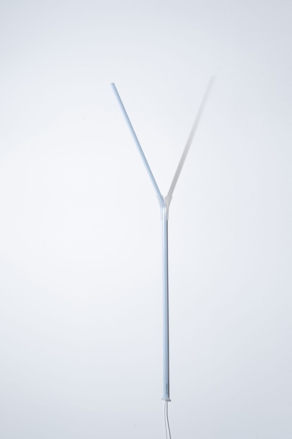 Weiße Ingo Maurer Wandleuchte "Measure Light" mit Y-förmigem Leuchtenarm und minimalistischem Design.