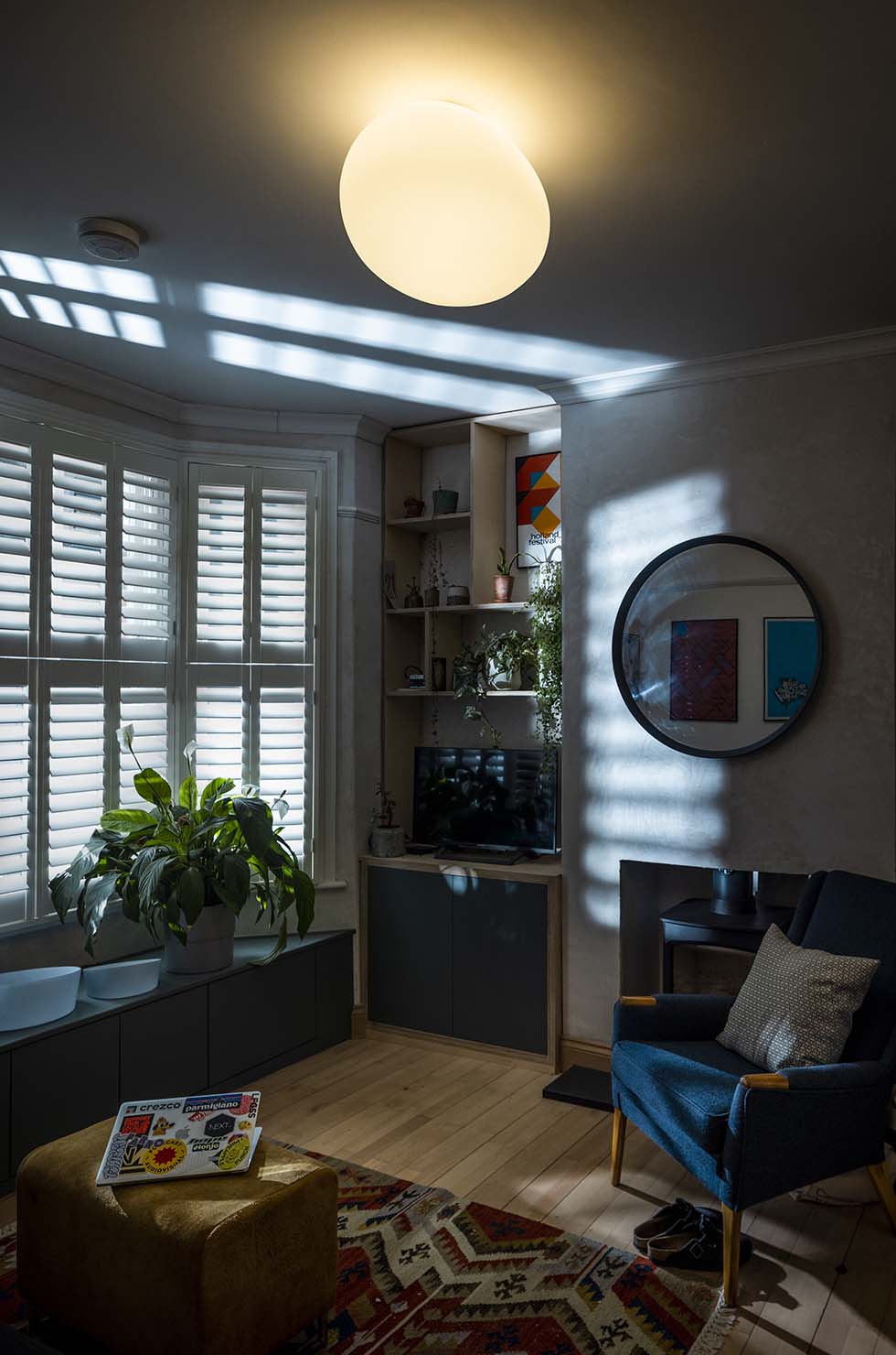 Wohnzimmer mit runder, weißer Gregg Deckenleuchte von Foscarini für stimmungsvolle Beleuchtung.