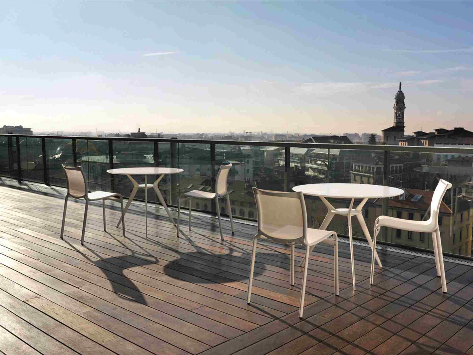 Bigframe Outdoor Stühle von Alias auf einer Dachterrasse mit Tischen und Stadtblick.