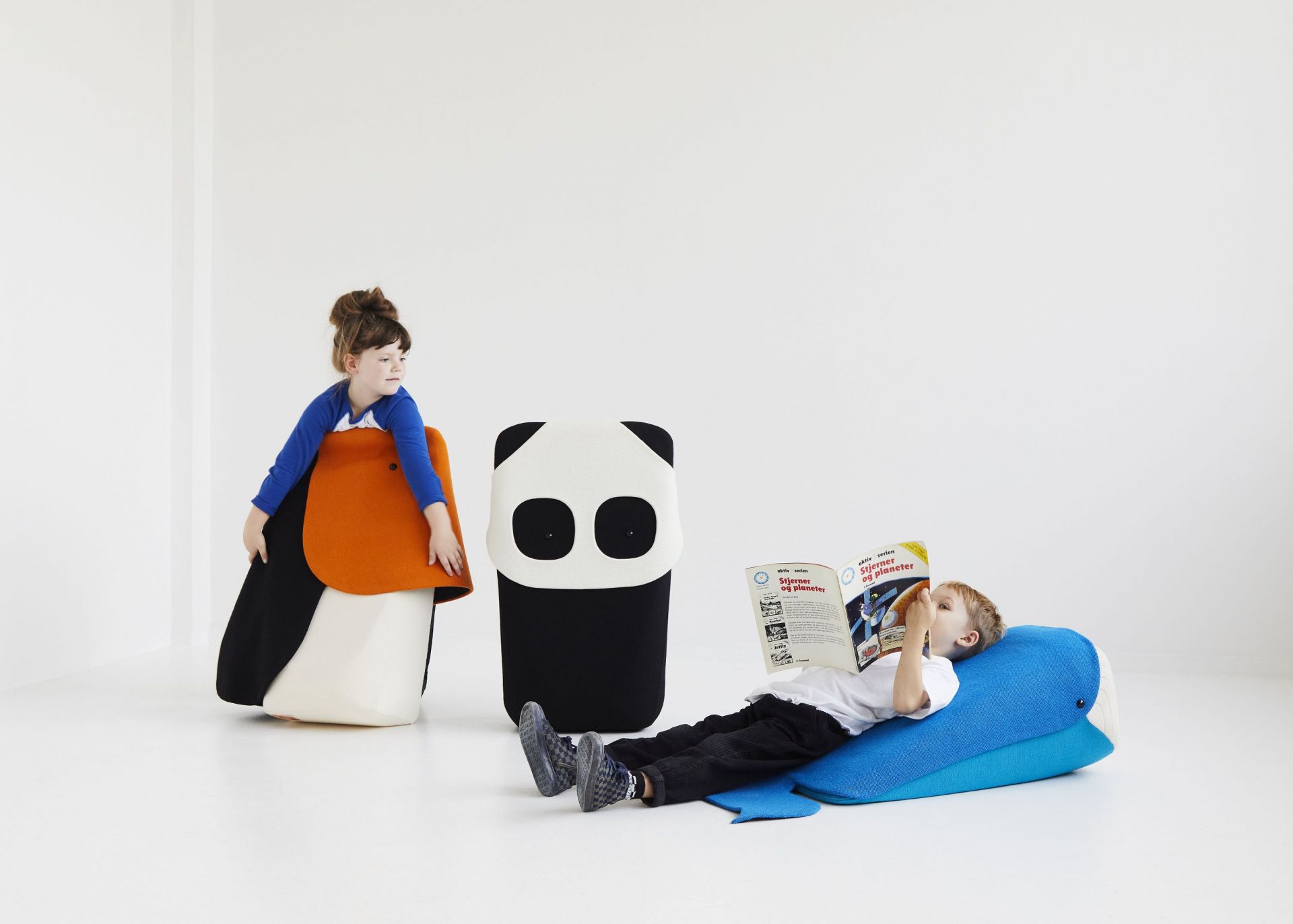 Zwei Kinder nutzen EO Denmark Zoo Collection Sitzkissen in Form von Tieren zum Spielen und Lesen.