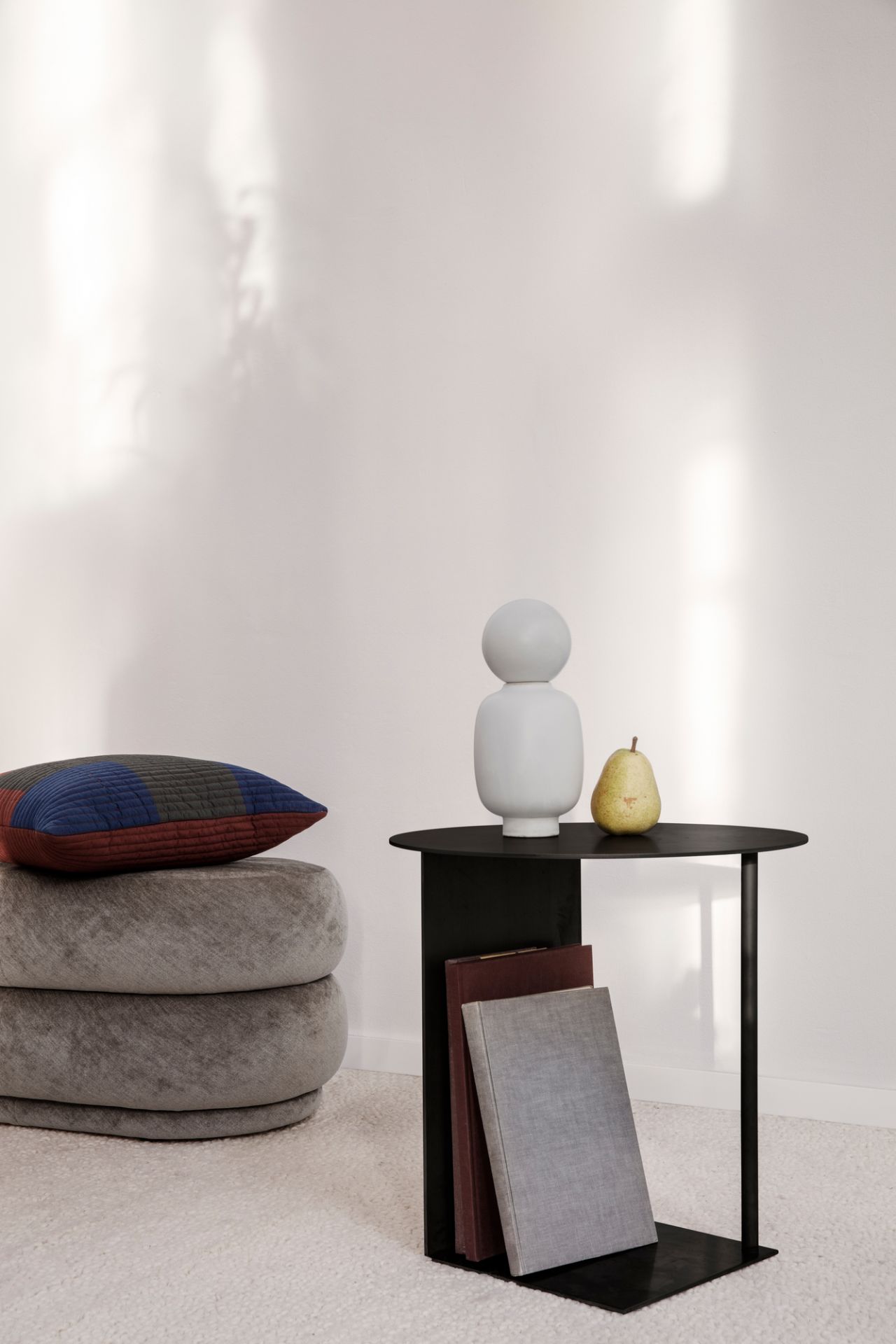 Ferm Living Pouf Hocker aus Samt in Grau mit Kissen und Beistelltisch.