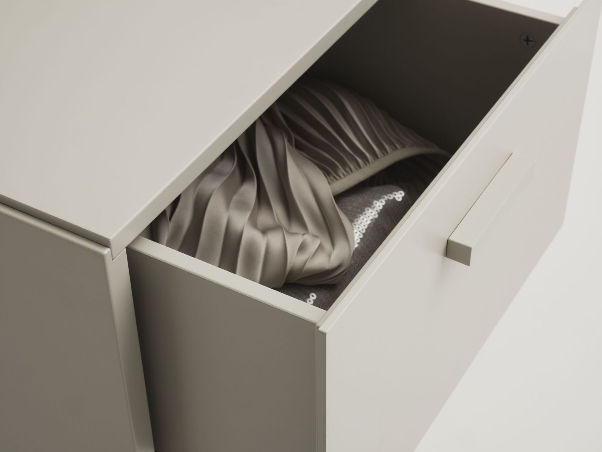 Geöffnete Schublade einer Relief Kommode von String Furniture mit Textilien. Möbel für Schlafzimmer und Wohnzimmer.