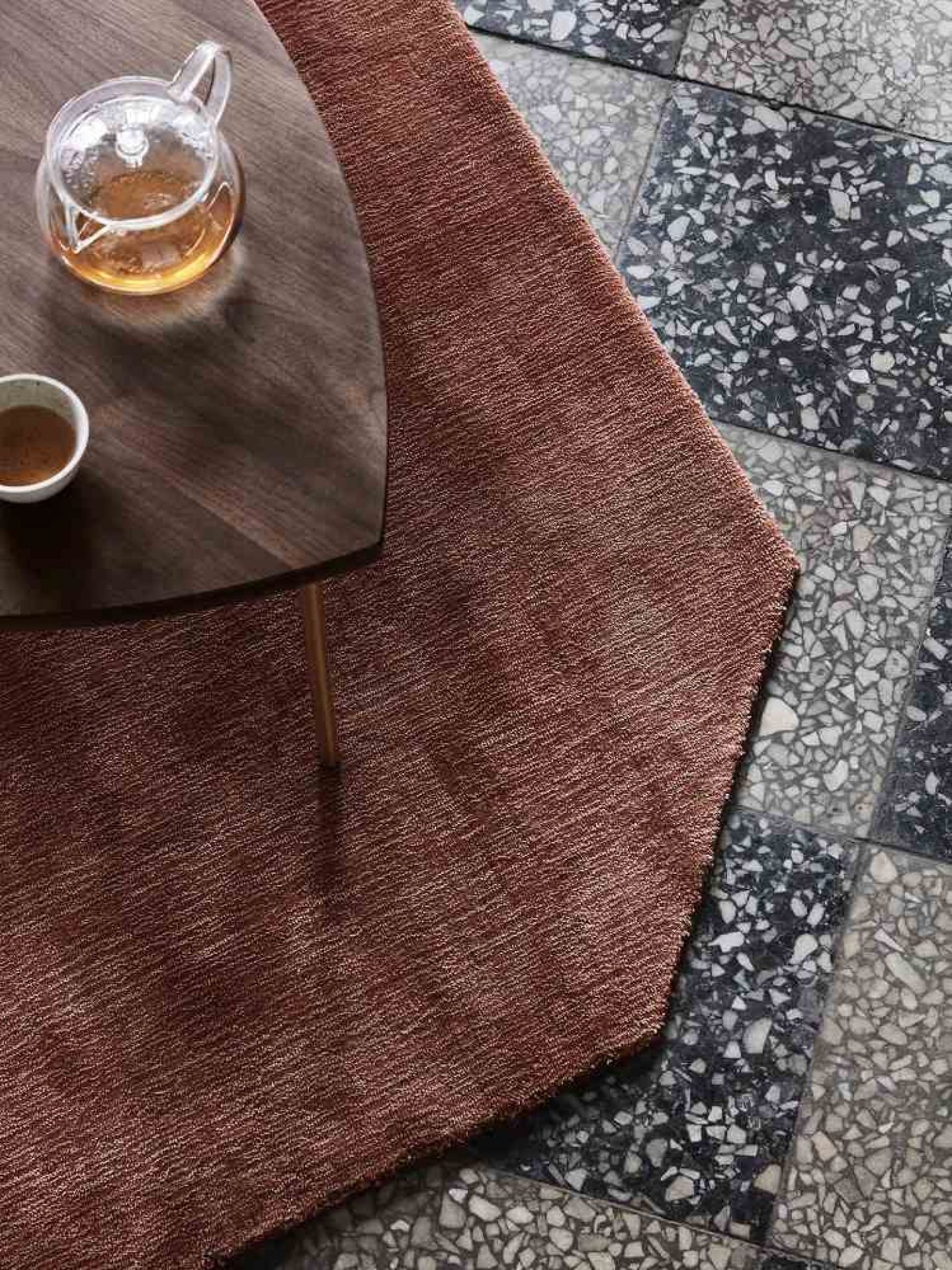 Nahaufnahme des AndTradition Pinwheel Beistelltischs mit Teekanne und Tasse auf einem braunen Teppich.