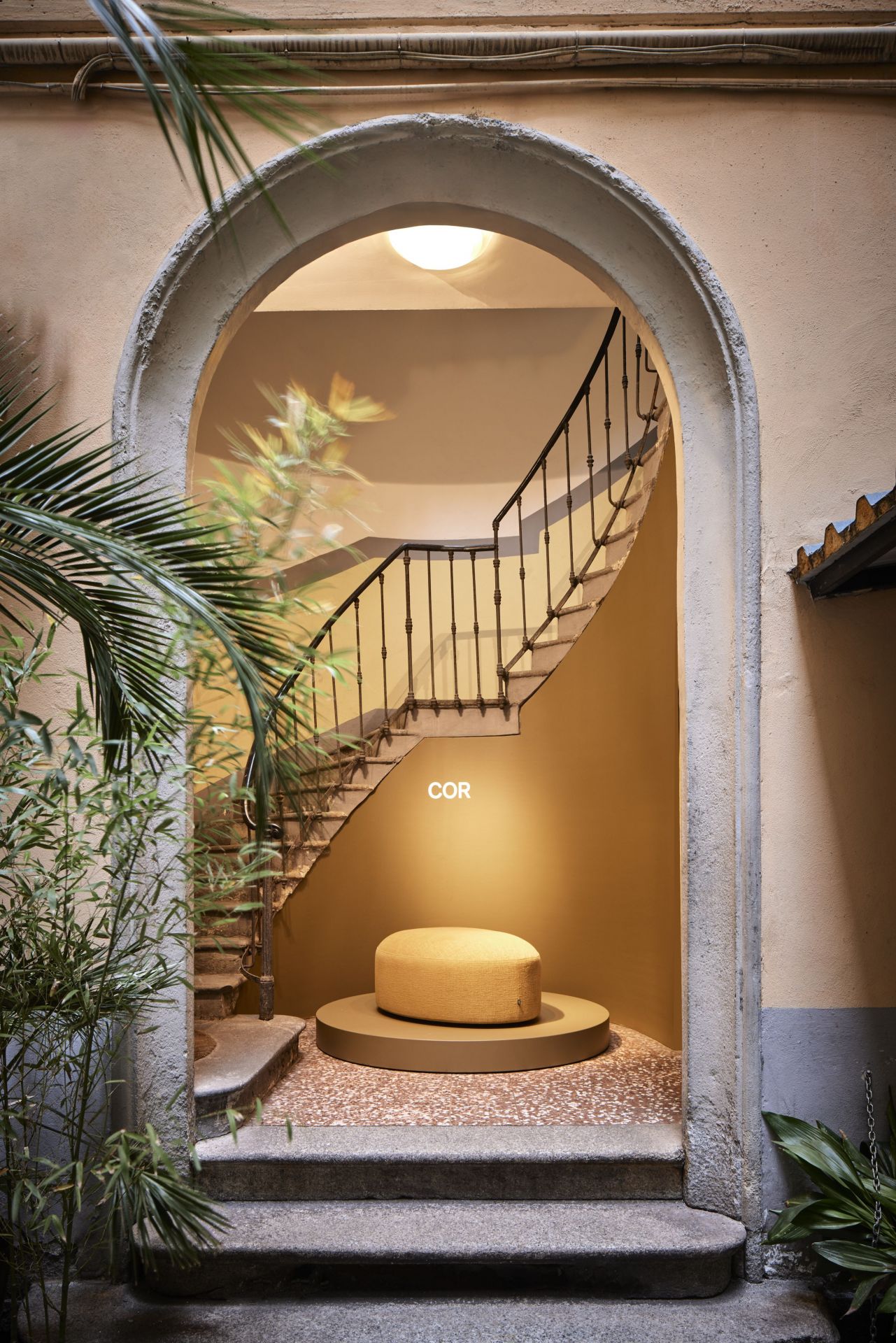 Gelber Siwa Hocker von Cor, platziert auf einer Plattform vor einer Wendeltreppe. Moderner Sitzhocker.