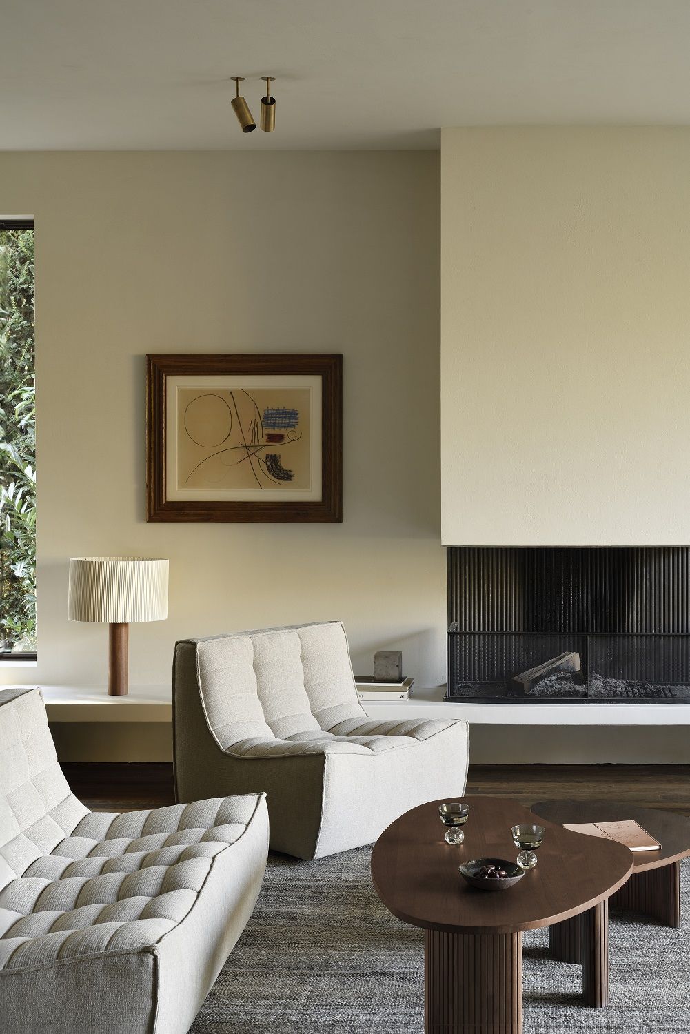 Wohnzimmer mit Ethnicraft Couchtisch in Kieselform, braunem Holz und modernem Design.