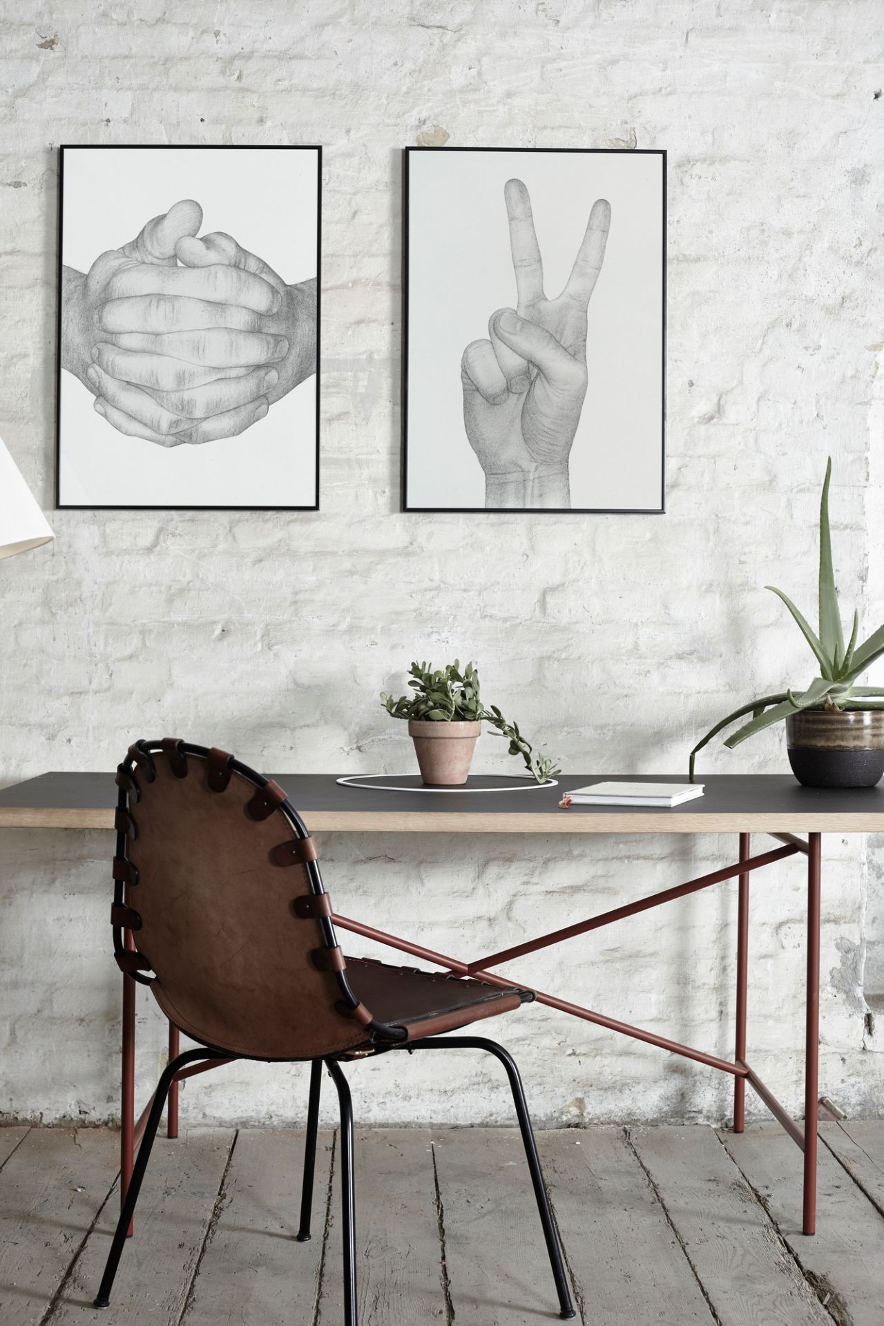 Nahaufnahme des Folded Hands Poster von Paper Collective, gerahmte Kunstdrucke an weißer Ziegelwand.