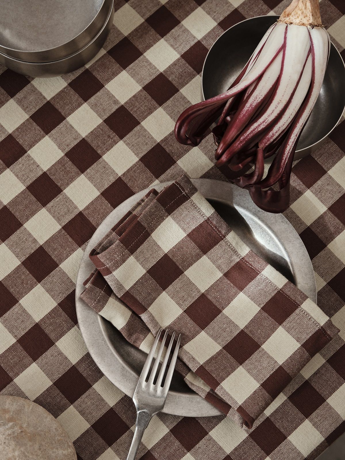 Ferm Living Tumbled Plate Campingteller auf karierter Tischdecke mit Serviette, Gabel und Radicchio in Schüssel.
