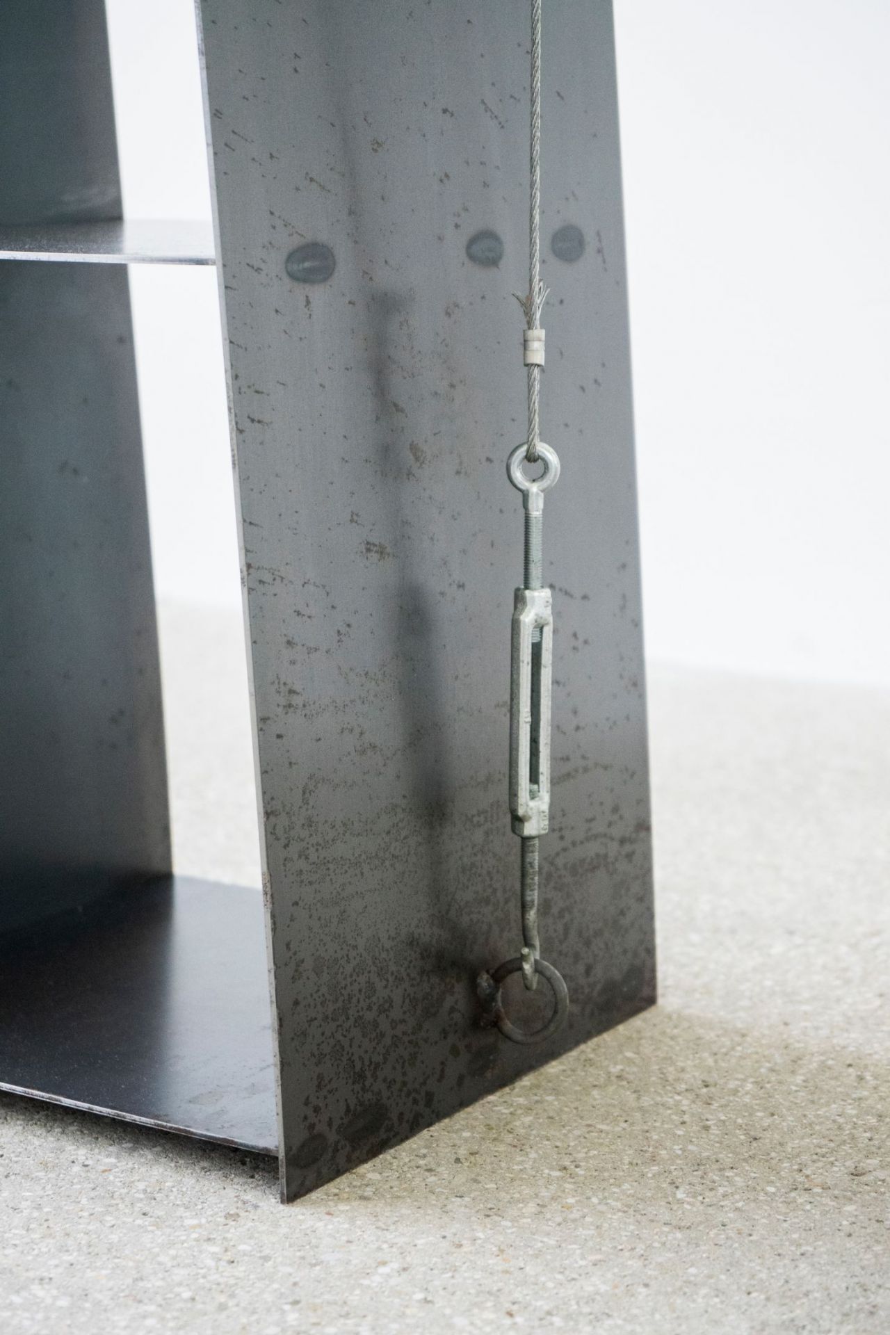 Detailaufnahme: Gespanntes Regal von Moormann mit Stahlseil-Spannsystem und Regalböden aus dunklem Metall.