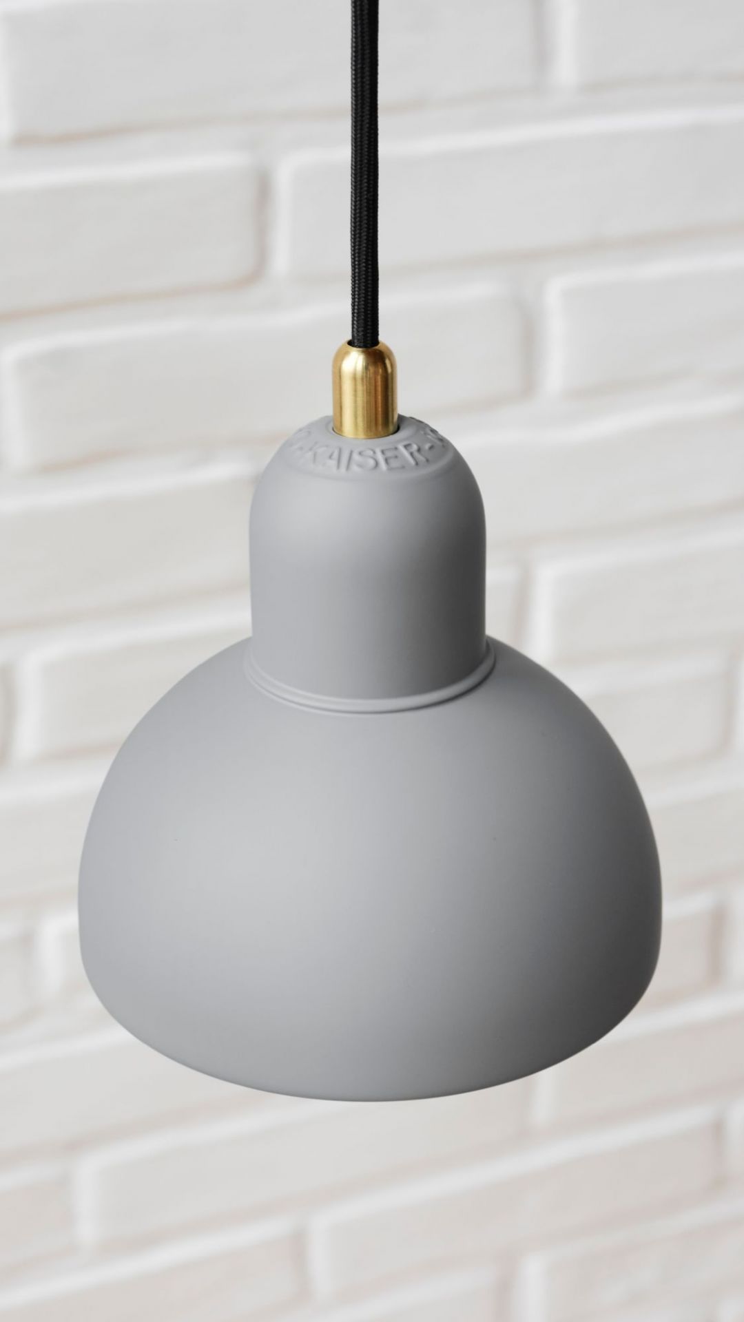 Graue 6722-P Pendelleuchte von Fritz Hansen mit schwarzem Kabel und goldenem Detail.