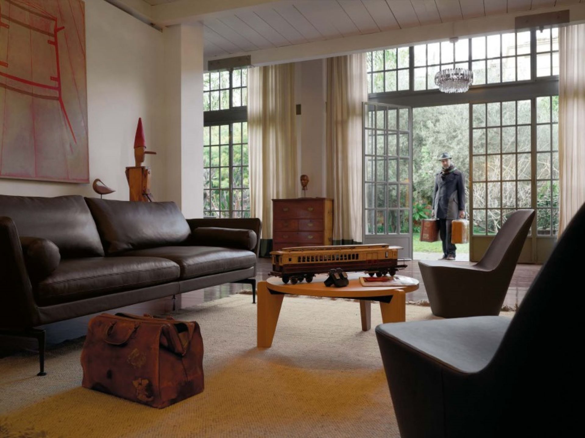 Wohnzimmer mit Vitra Gueridon Beistelltisch aus Holz, Sofa und Sessel.