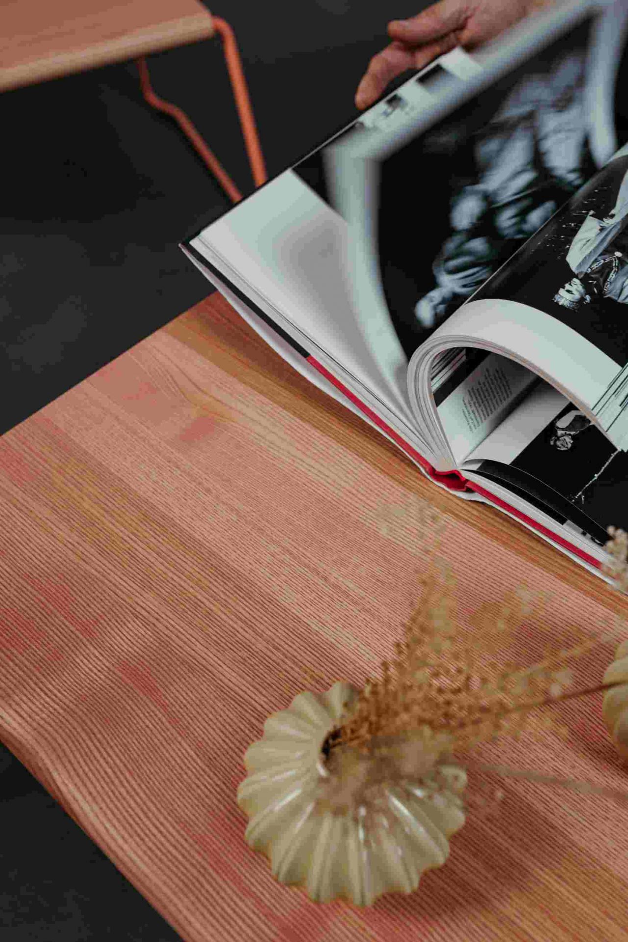 D:009 Coffeetable Kohleschwarz Fuchs & Habicht mit Buch, Vase und Trockenblumen auf der Tischplatte.