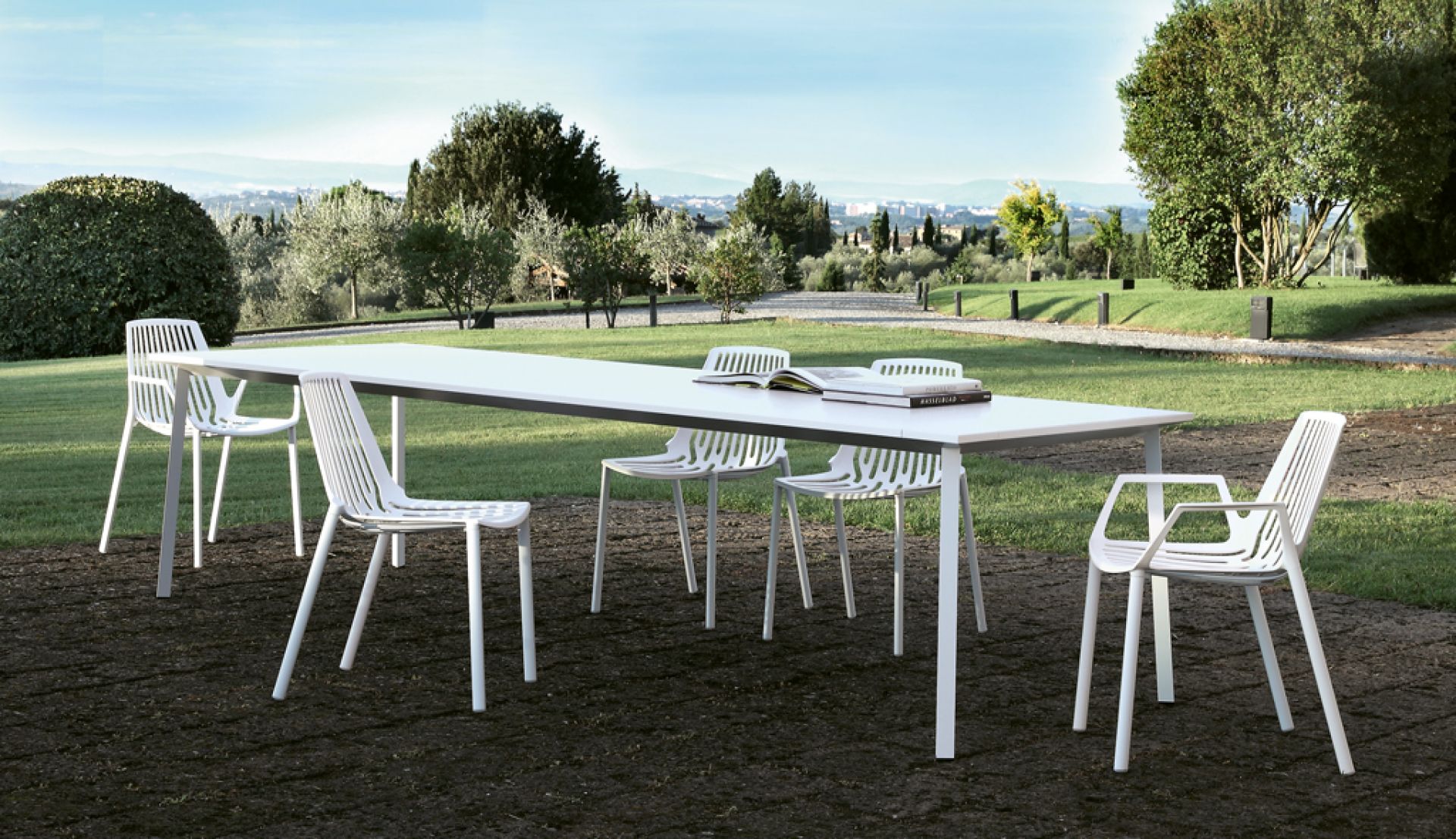 Bild von weißen Rion Outdoor Sesseln und einem Esstisch im Garten. Gartenmöbel für Terrasse und Balkon.