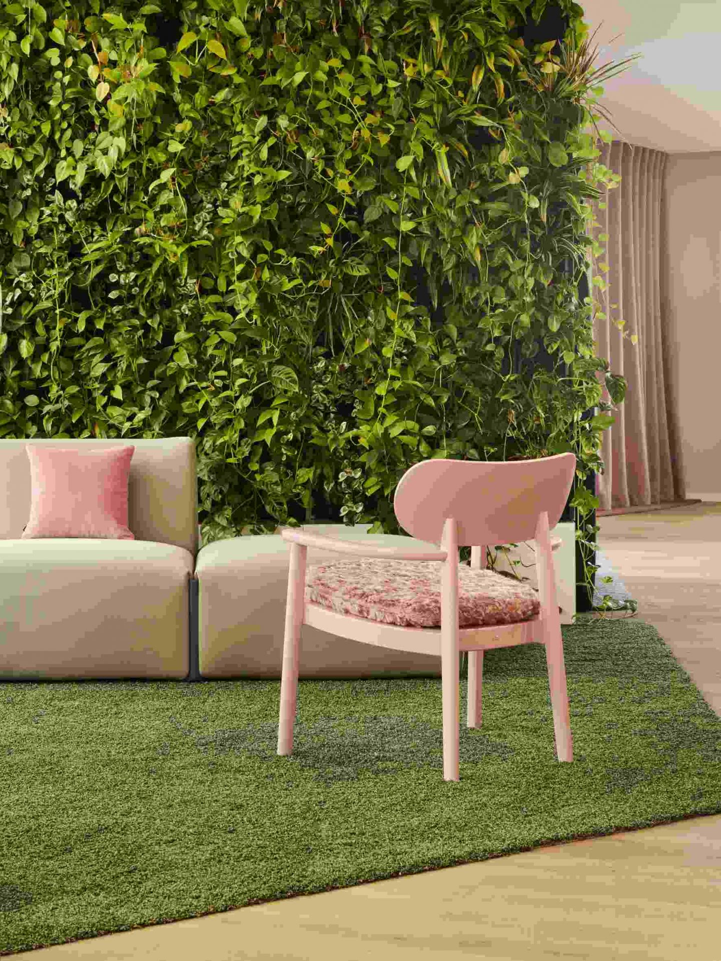 Rosa Loungesessel mit Armlehnen von Thonet, LIMITED EDITION, vor grüner Wand und Teppich.