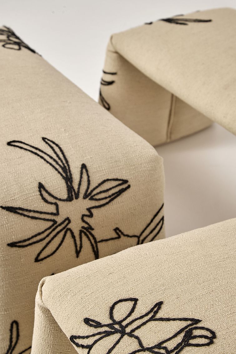 Detailaufnahme der Nanimarquina Flower Bench Bank L mit beigem Stoff und schwarzer Blumenstickerei.