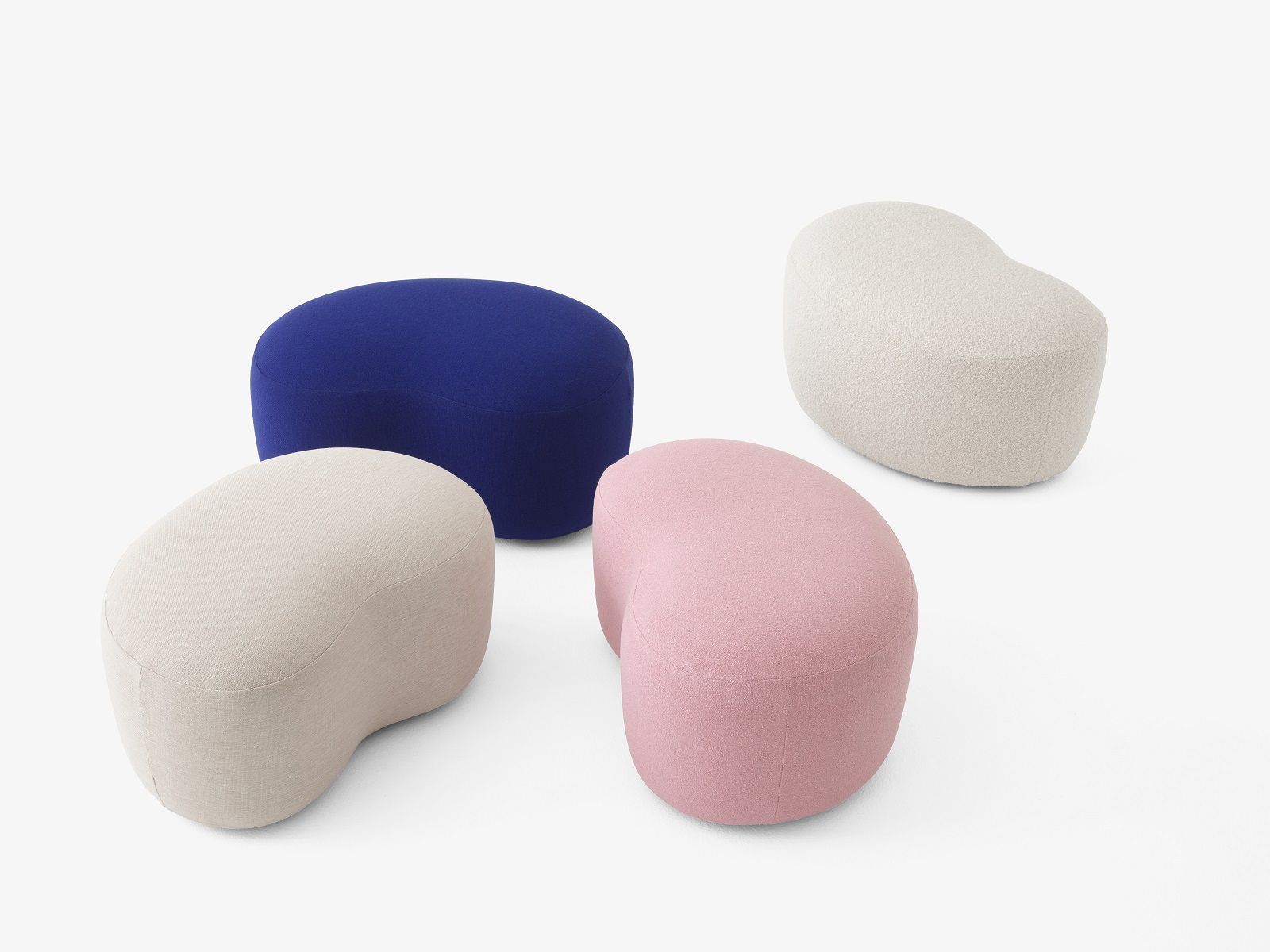 Vier Margas Pouf Hocker von AndTradition in Blau, Rosa, Beige und Weiß auf weißem Hintergrund.