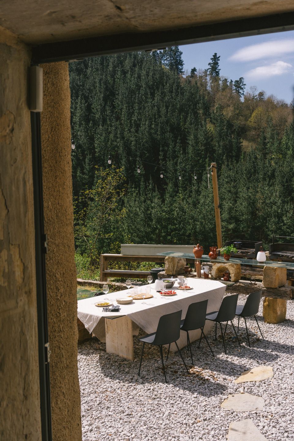 Esstisch im Freien mit vier Rely HW70 Stühlen von AndTradition auf Kiesboden.