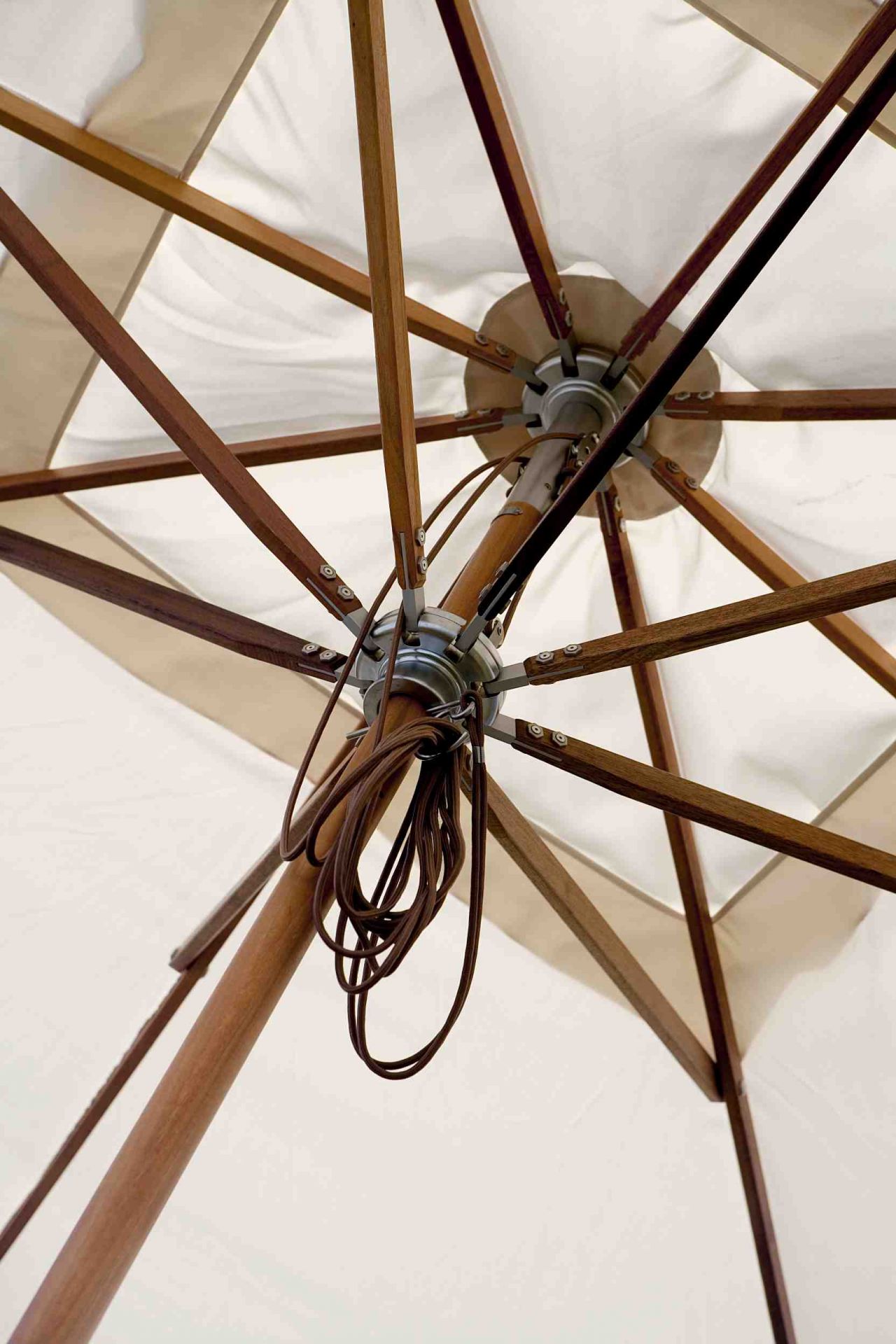Detailaufnahme des Atlantis Sonnenschirms von Skagerak mit Holzgestell und beigem Schirmstoff.