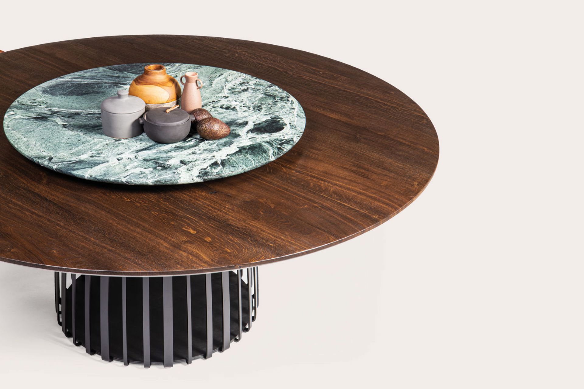 BC 07 Basket Tisch von Janua: Runder Holztisch mit schwarzem Metallfuß und Dekoration.