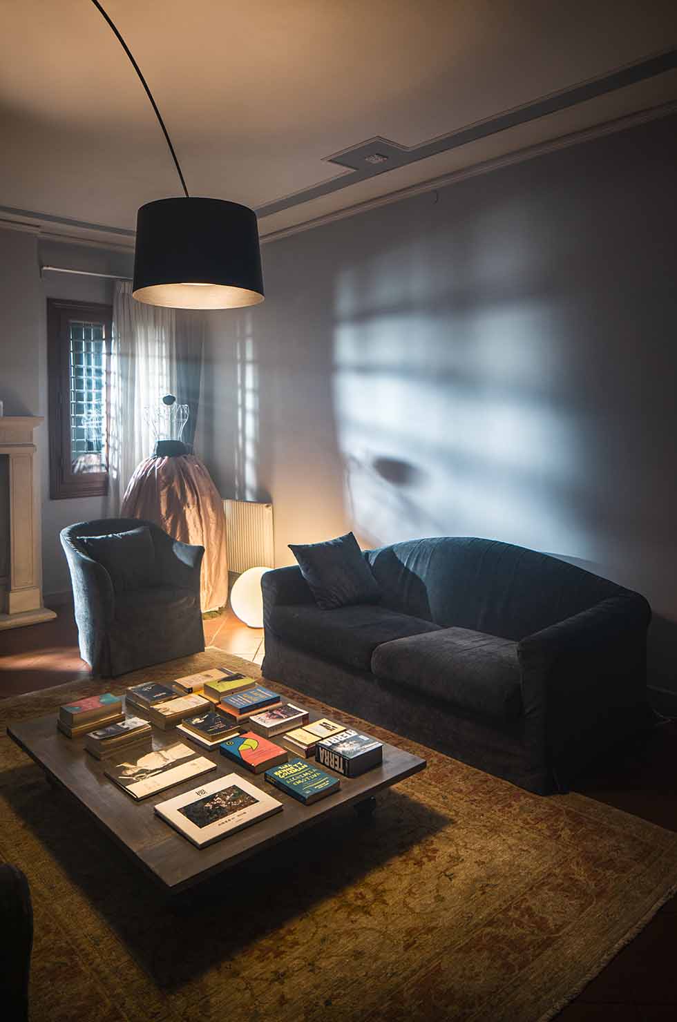 Wohnzimmer mit grauer Couch und der Twiggy Elle Terra LED Stehleuchte von Foscarini in Graphit.