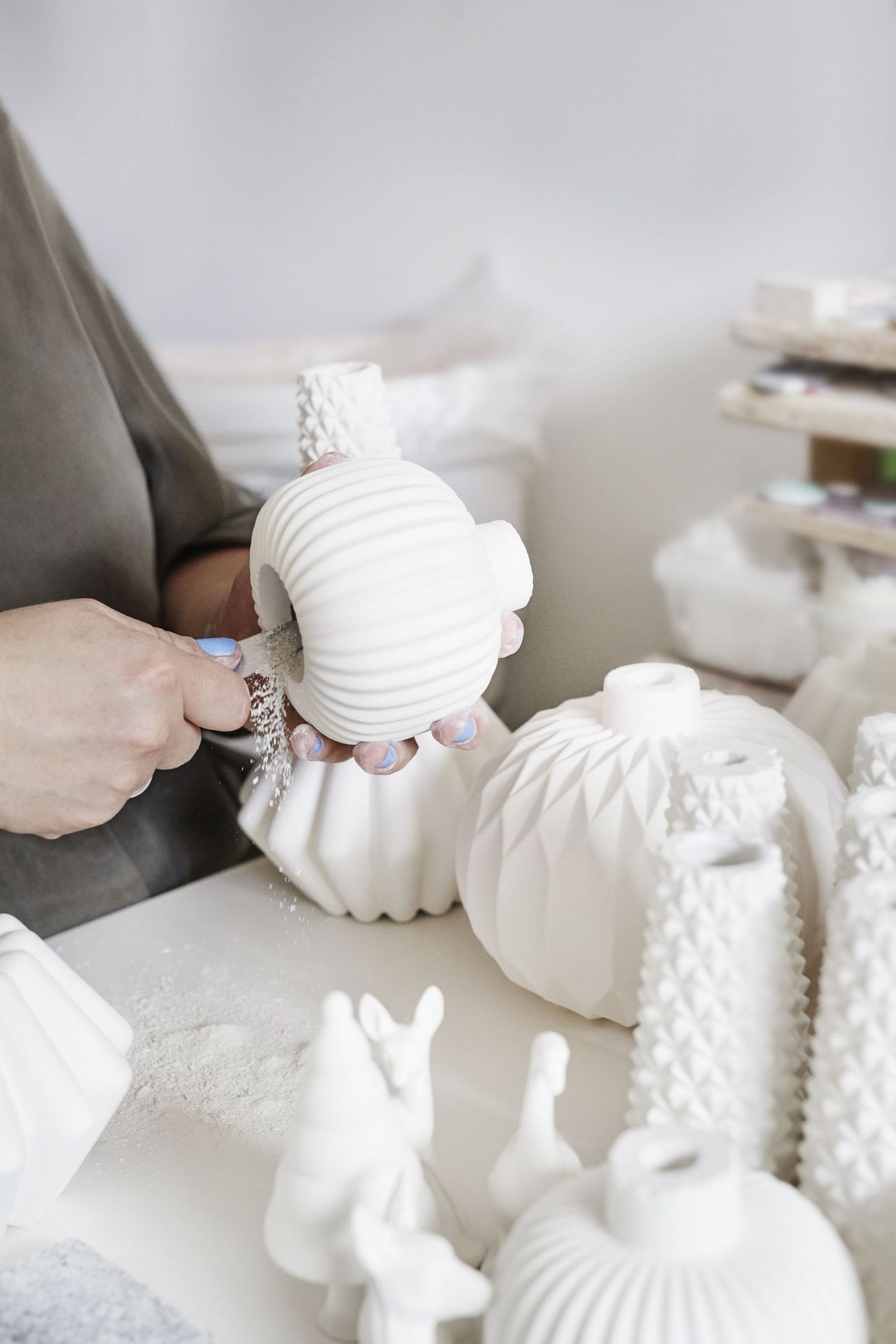 Detailaufnahme: Hand bearbeitet Winter Stories Rehkitz Teelichthalter, weiße Keramik, Dottir Einzelstück, festliche Weihnachtsdekoration.