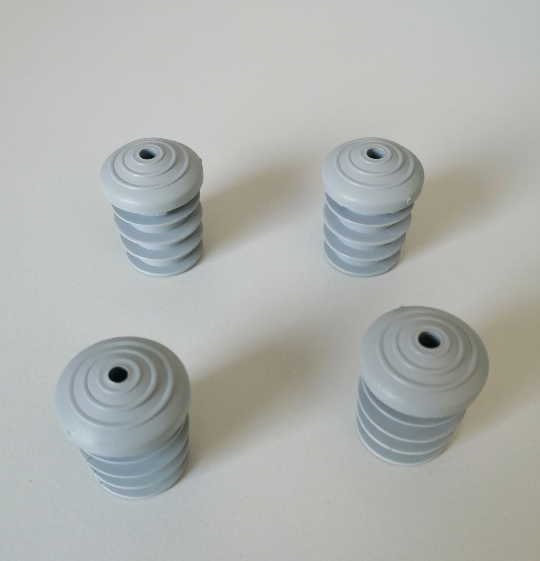 Vier graue Breeze Kunststoffgleiter von Segis für Stühle und Möbel, Detailansicht.