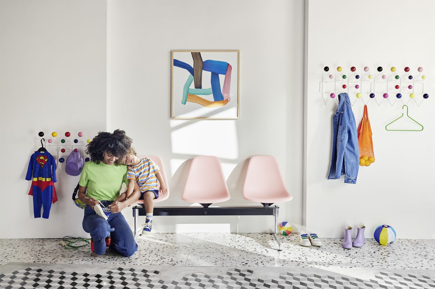 Eames Plastic Side Chair RE auf Traverse von Vitra in Rosa, Wartebereich mit Familie.