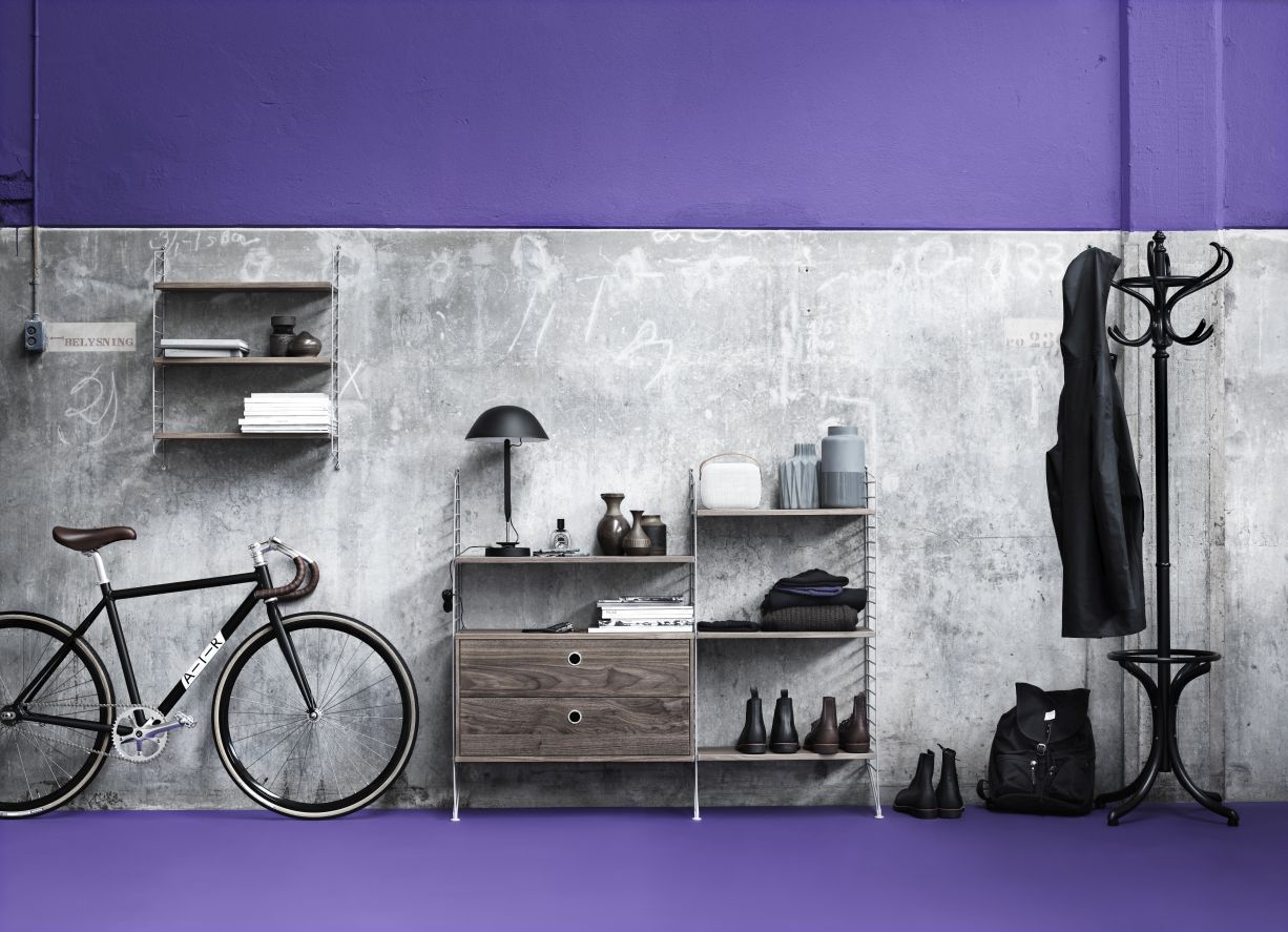 String Furniture Regalsystem mit Schubladenelement in Walnuss, kombiniert mit Regalböden und Accessoires.