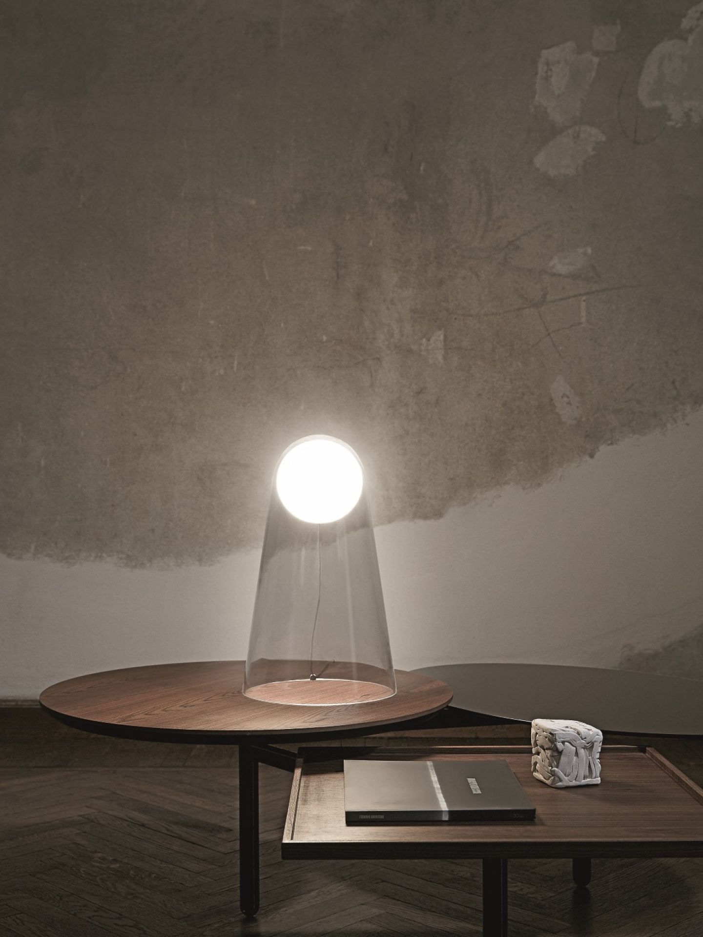 Satellight Tischleuchte von Foscarini: Moderne Lampe mit klarem Schirm auf einem Holztisch.