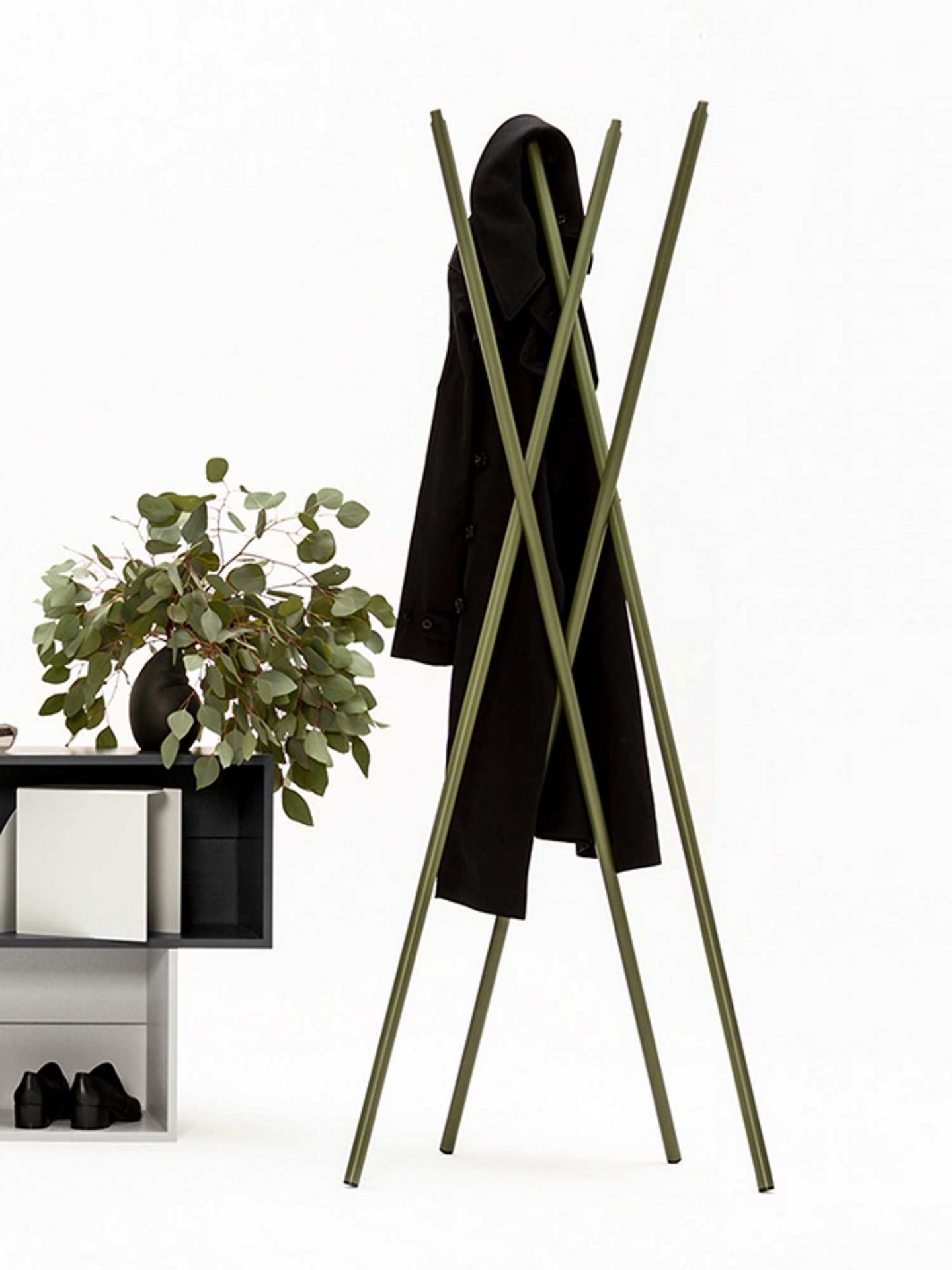 Grüne Hash Garderobe von New Tendency mit schwarzem Mantel, minimalistische Flurgarderobe für Jacken und Kleidung.